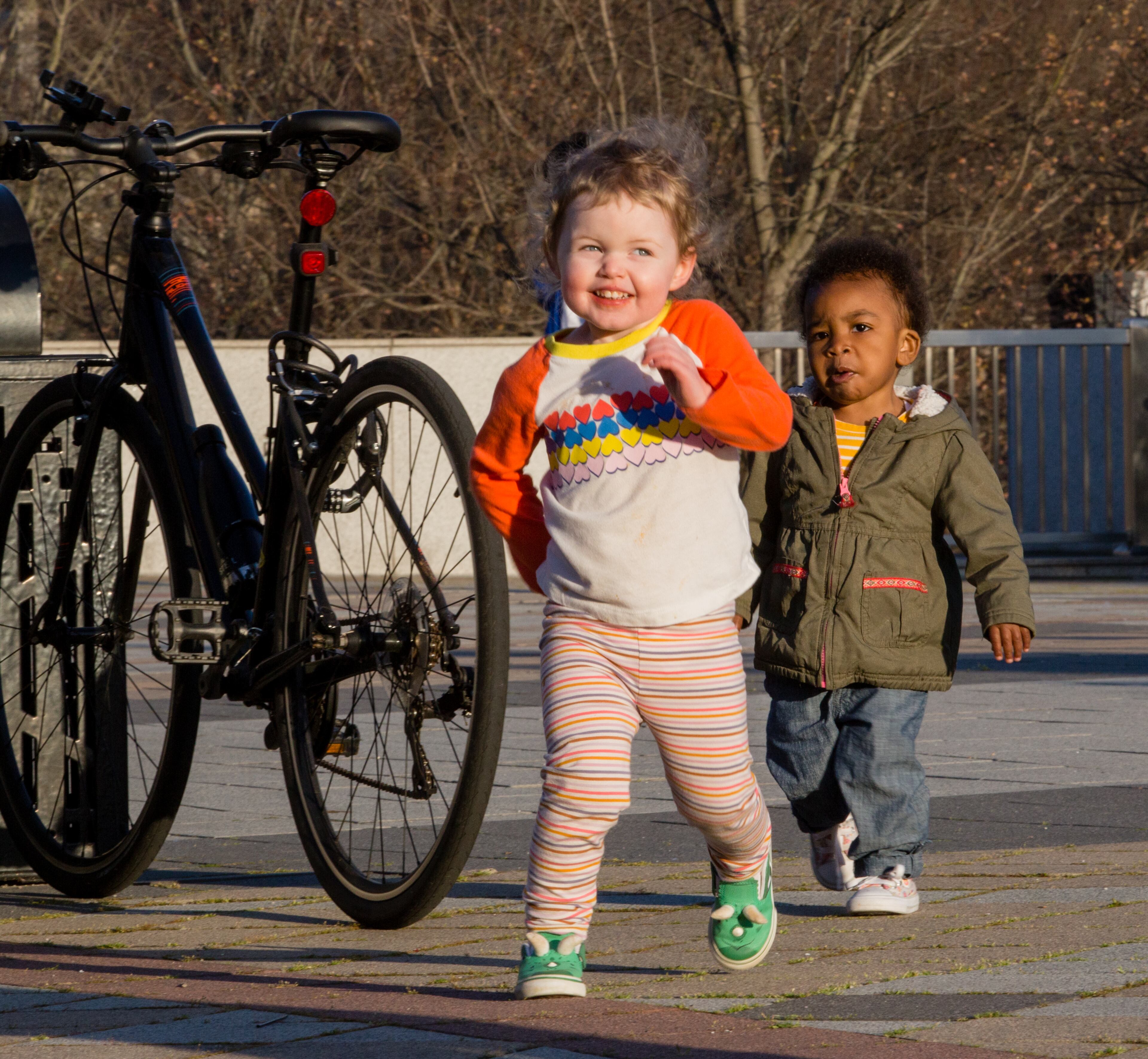 Decatur Square is busy on the first official day of spring, Saturday, March 20, 2021 with families and outdoor diners enjoying the weather, live music and food options. Ellie Walters, 3 (front), makes friends with 2-year-old Amora Barfield of Tucker on the sunny day. (Jenni Girtman for The Atlanta Journal-Constitution)