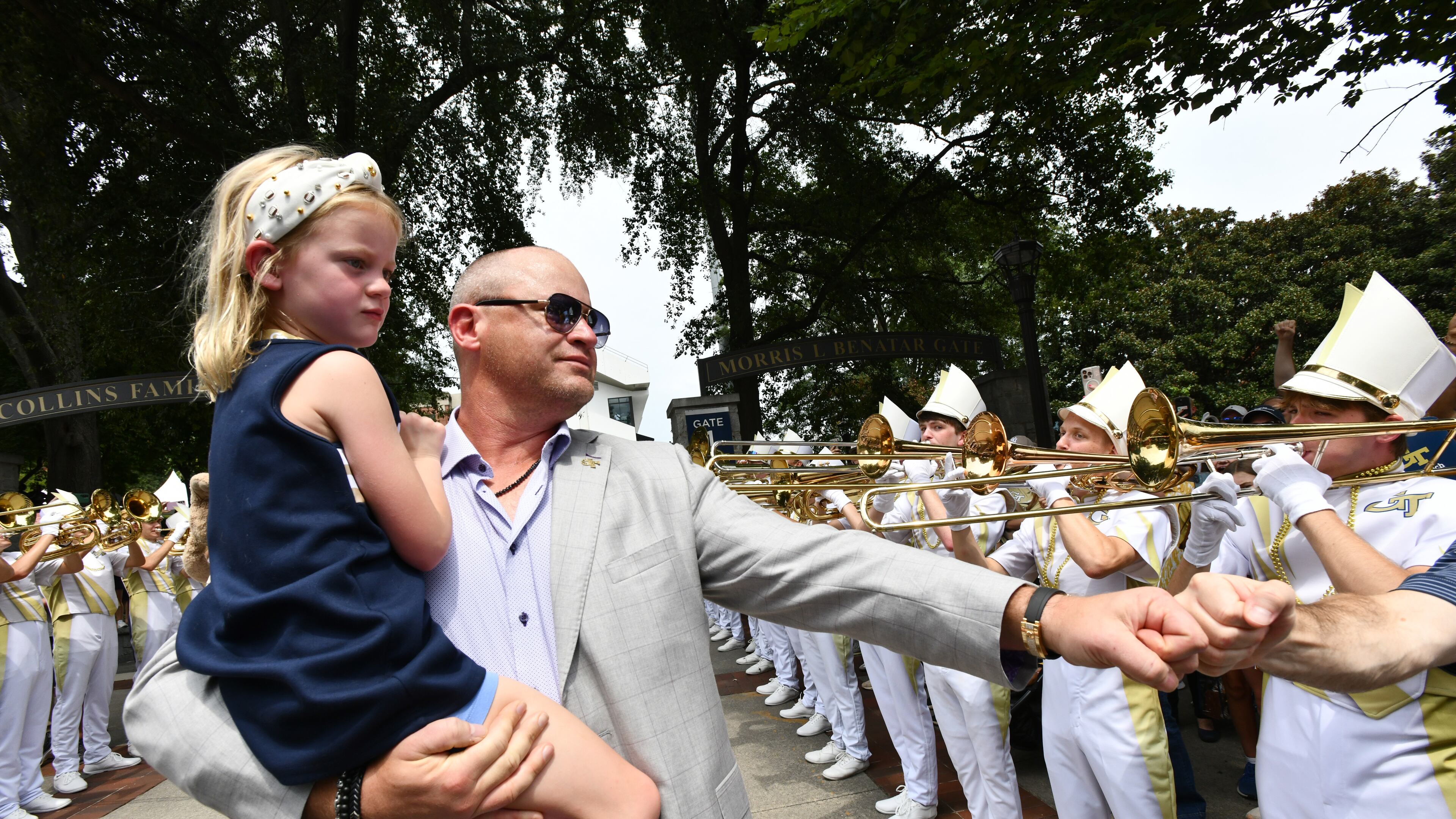 Georgia Tech coach Brent Key and his daughter, Harper, arrive with players and coaches before the home opener Sept. 6, 2025, against Gardner-Webb at Bobby Dodd Stadium in Atlanta. (Hyosub Shin/AJC)