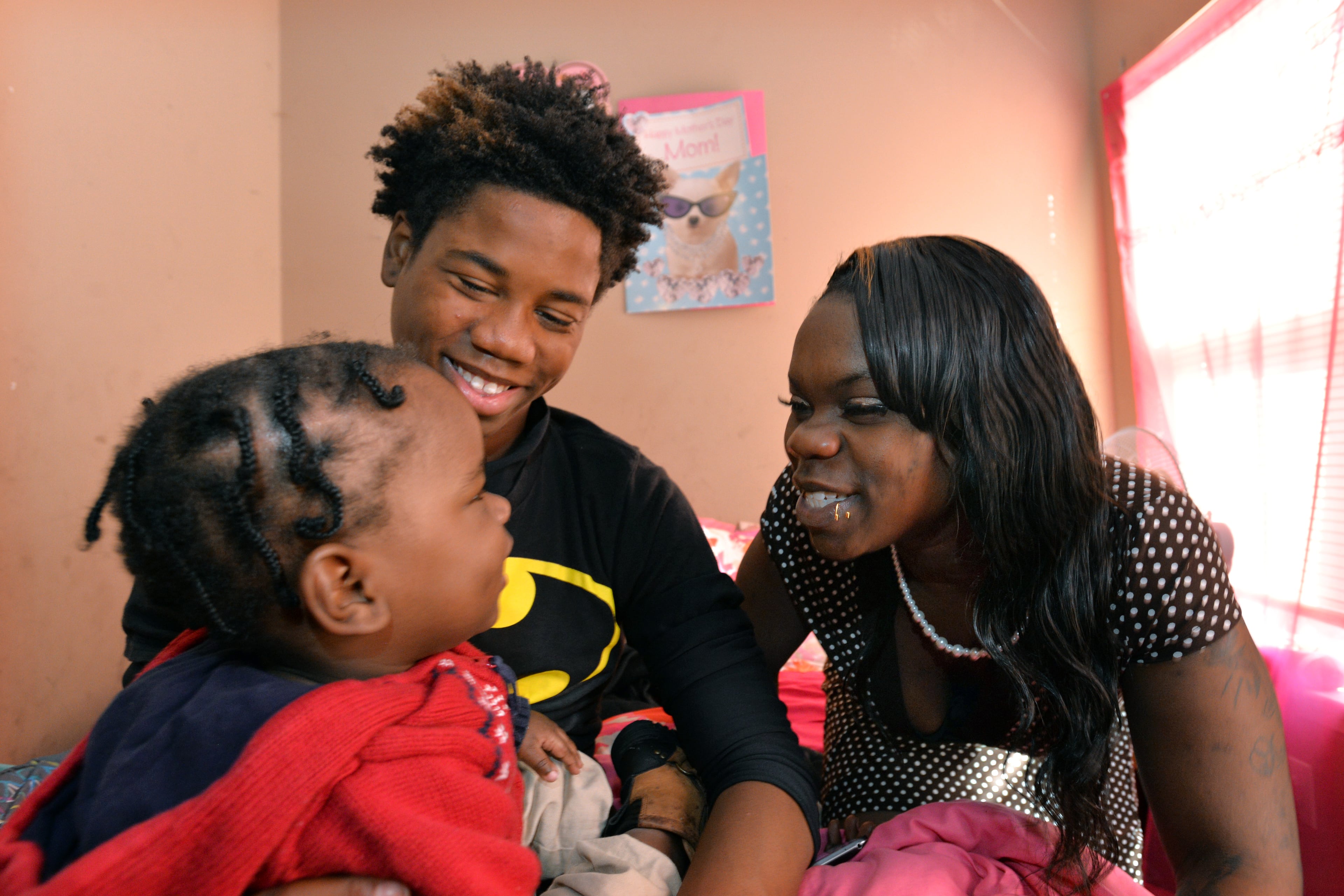 Donna’s children Ashley Roberson (right), 23, and Dayzhon Marshall, 15, get Ashley’s son, Demetrius Broadnax Jr., 1, ready to go to church services one Sunday earlier this month. HYOSUB SHIN / HSHIN@AJC.COM