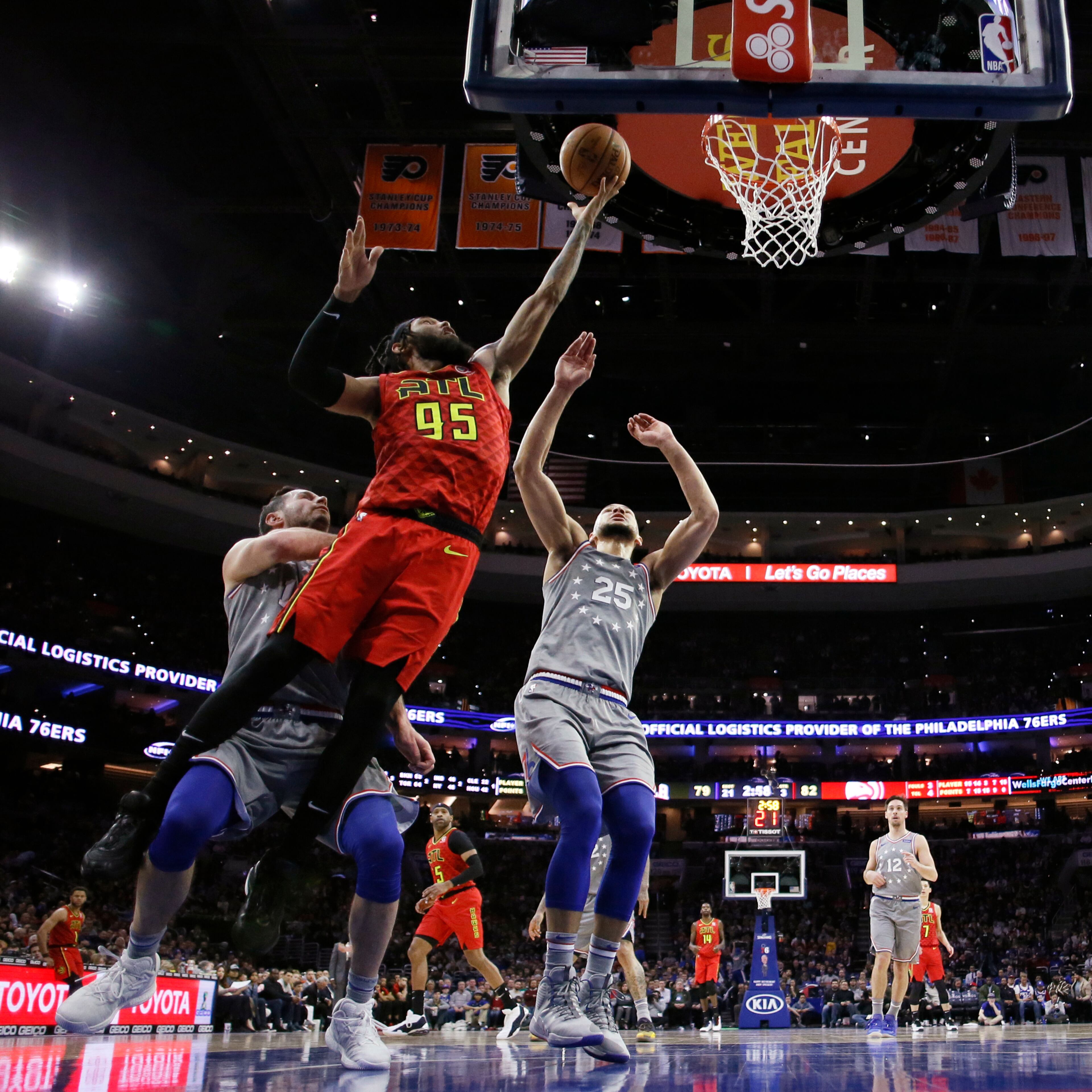 Atlanta Hawks' DeAndre' Bembry, center, goes up for a shot between Philadelphia 76ers' JJ Redick, left, and Ben Simmons during the second half of an NBA basketball game Friday, Jan. 11, 2019, in Philadelphia. Atlanta won 123-121. (AP Photo/Matt Slocum)