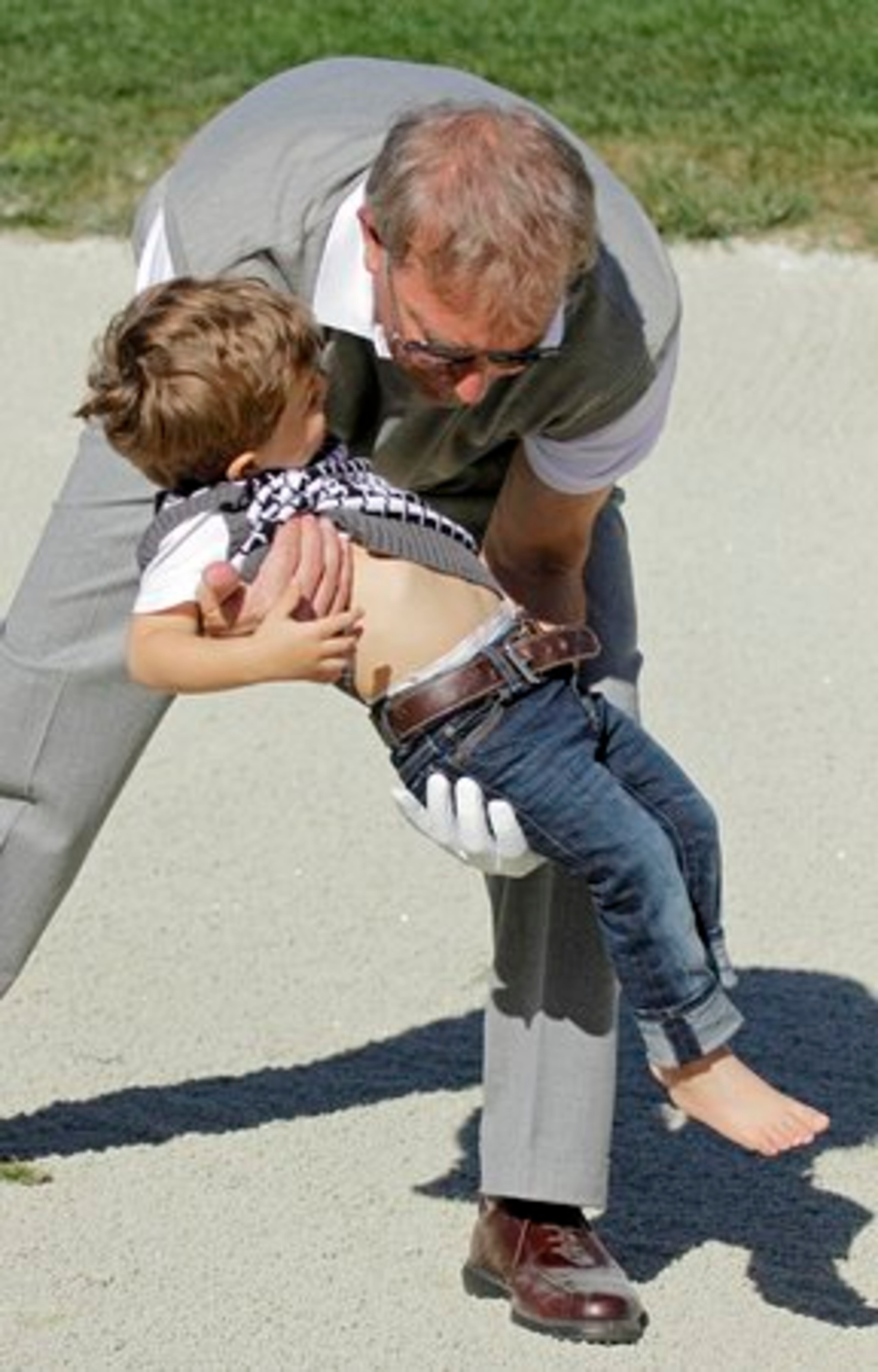 Actor Kevin Costner finally catches his 2-year-old son Hayes and removes him from the sand trap.