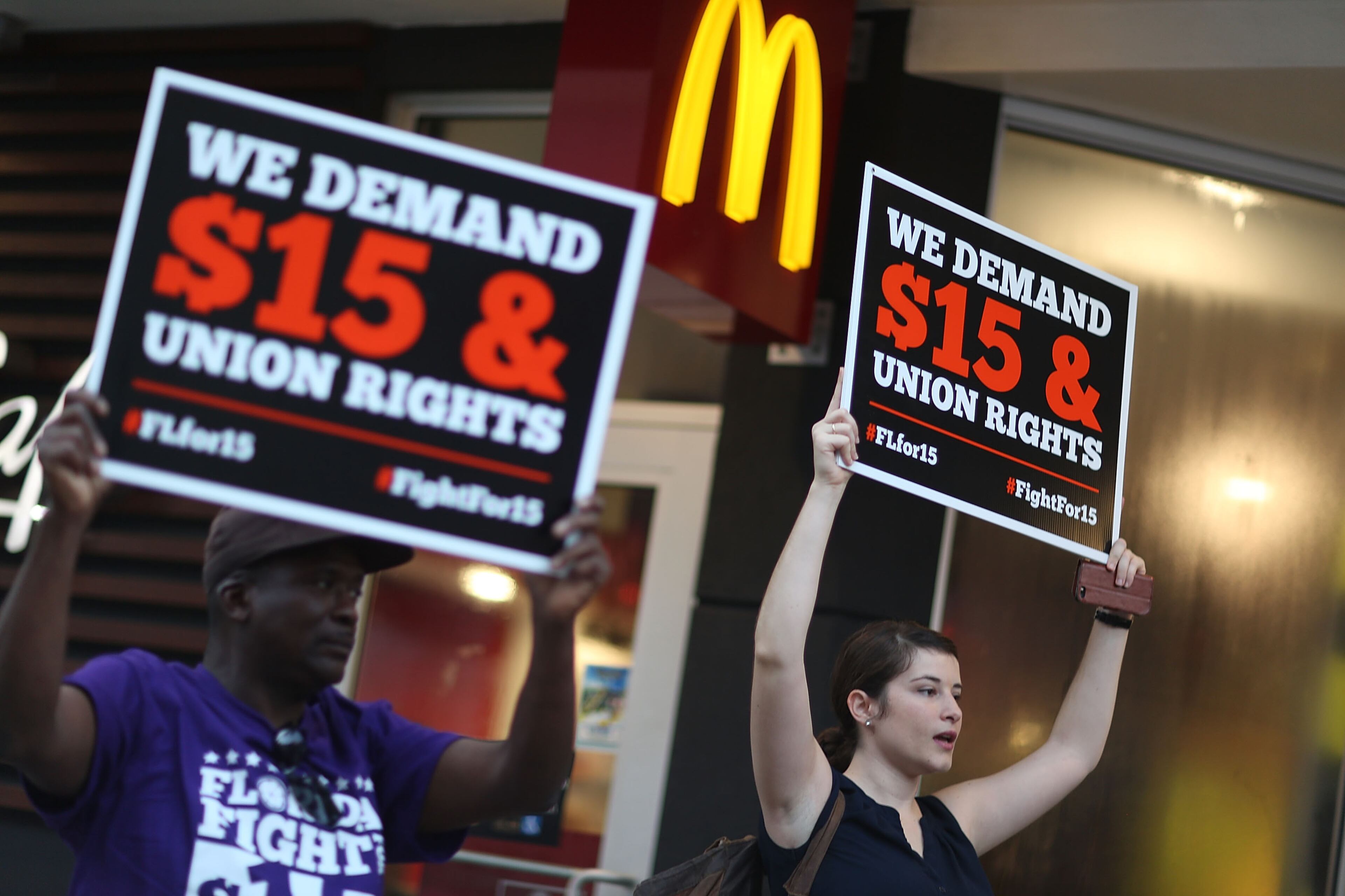 MIAMI, FL - NOVEMBER 10: Cecelia O'Brien (R) joins other workers to protest outside a McDonald's restaurant on November 10, 2015 in Miami, Florida. The protesters are demanding action from state legislators and presidential candidates to raise the minimum wage to $15 an hour. (Photo by Joe Raedle/Getty Images)