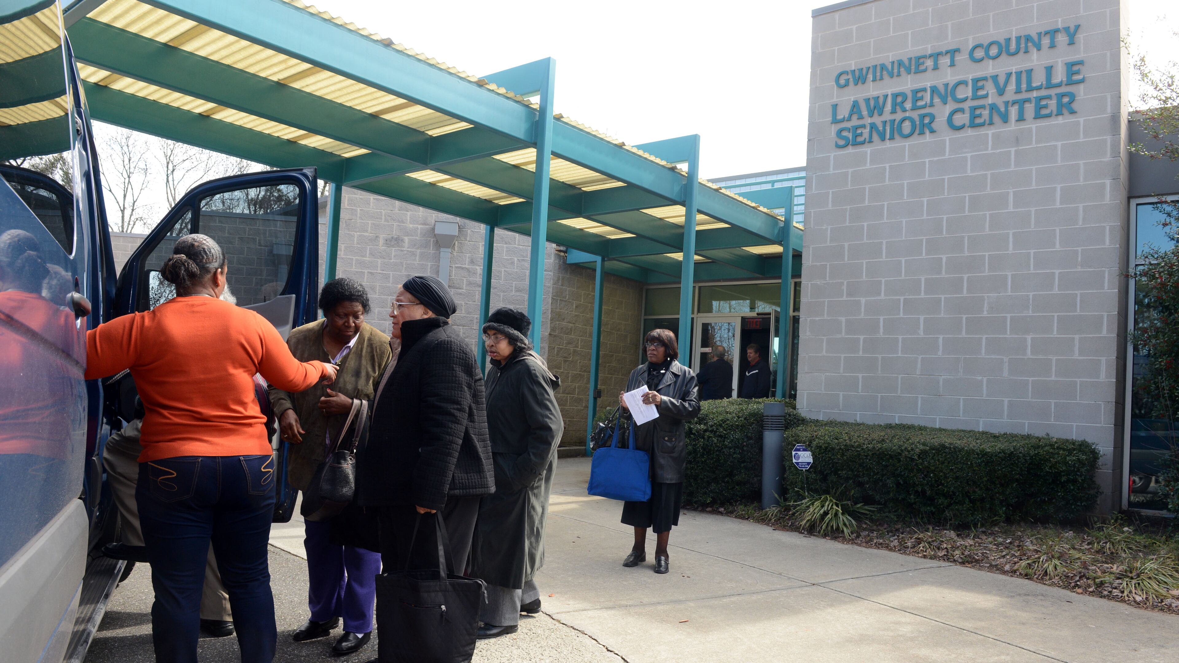 Driver Freddie Johnson helps seniors into a van for a ride home at the Lawrenceville Senior Center on Wednesday. The Gwinnett Senior Center is expecting to get less money and as a result, they plan to cut the number of rides and meals they give to seniors. Normally nearly 100 seniors come to the center each day for activities and lunch.