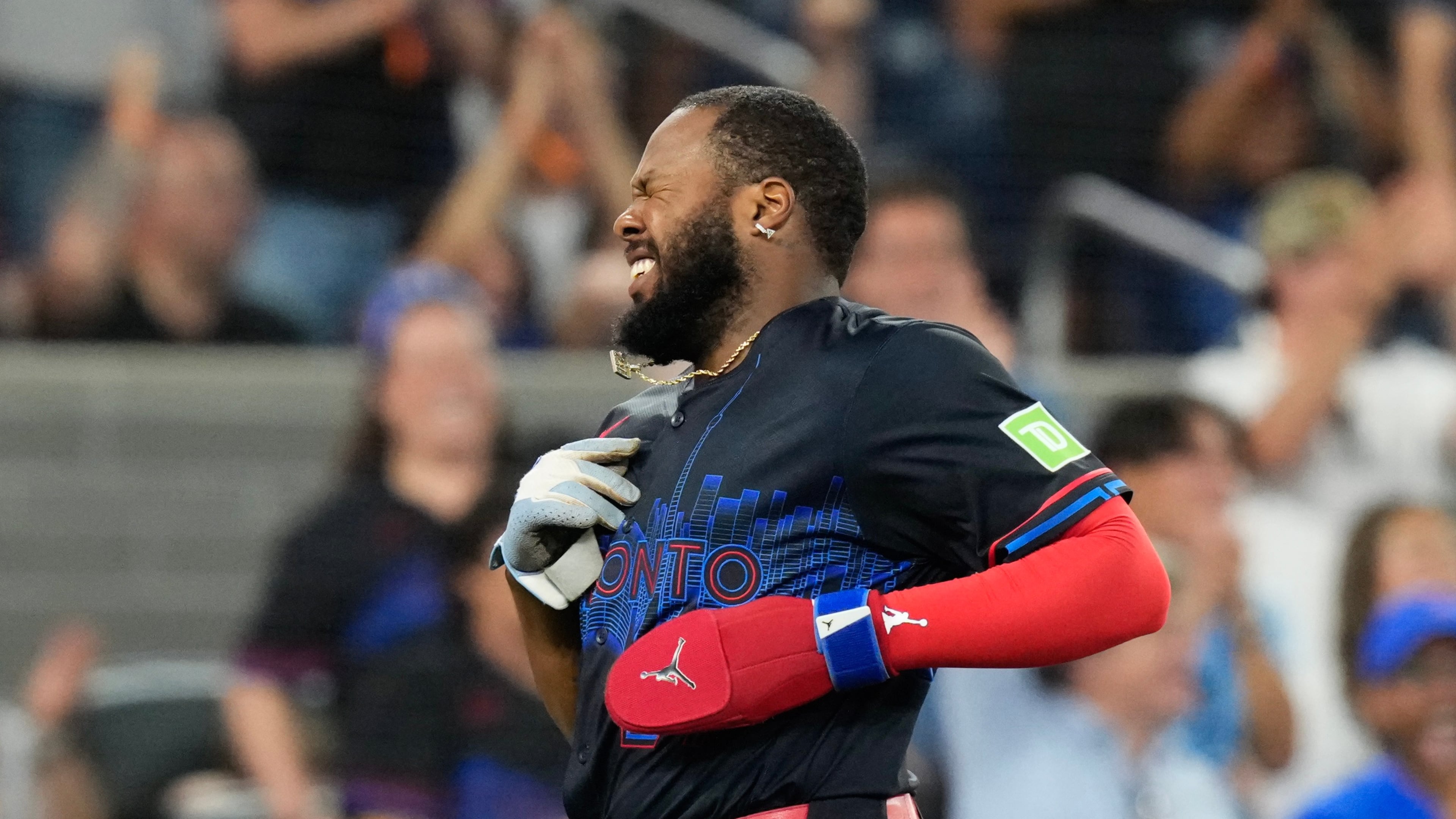 Toronto Blue Jays Vladimir Guerrero Jr. (27) grimaces as he crosses the plate after scoring following a throwing error by New York Yankees first baseman Luis García Jr. (26) during the first inning of a baseball game in Toronto, Friday, Aug. 14, 2026. (Chris Young/The Canadian Press via AP)