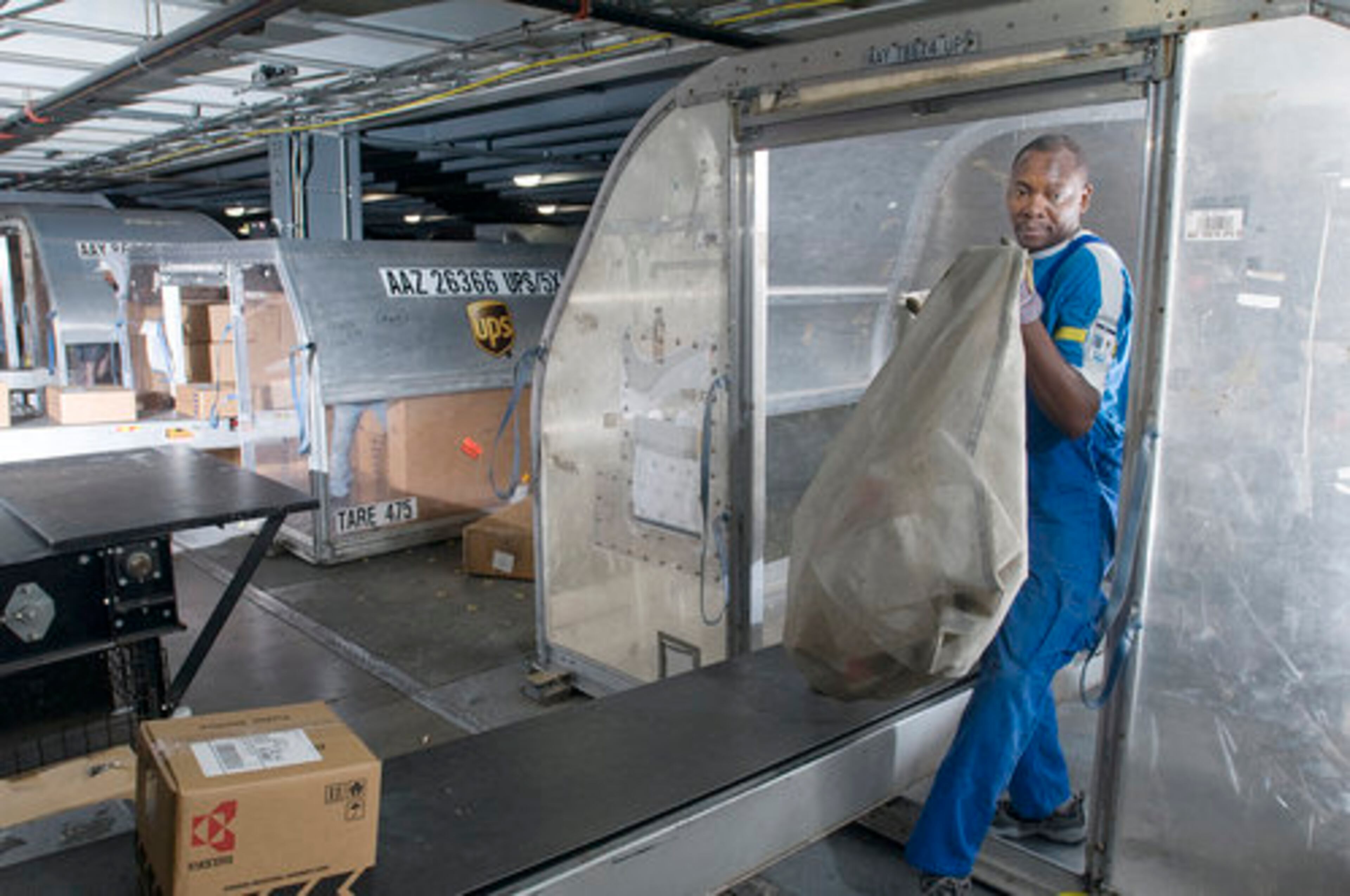 Napoleon Akayez unloads a bag from a UPS can.