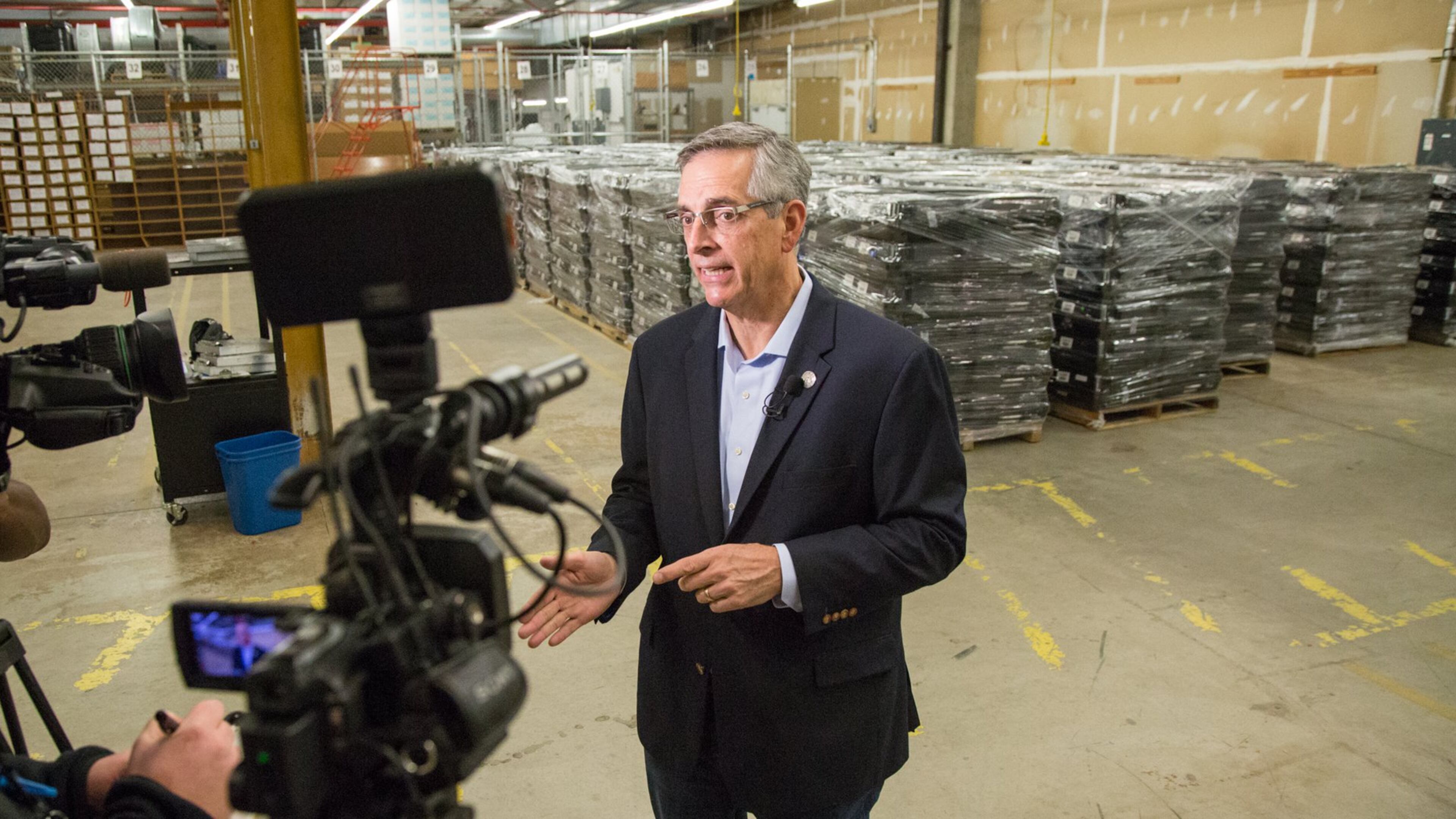 The Secretary of State Brad Raffensperger talks to the media in front of old voting machines while waiting for the largest shipment of Georgia’s new secure paper-ballot voting machines at the Dekalb County Voter Registration & Elections offices in Avondale Estates on Monday December 30th, 2019. 2839 units are to be delivered for Dekalb County. (Photo by Phil Skinner).