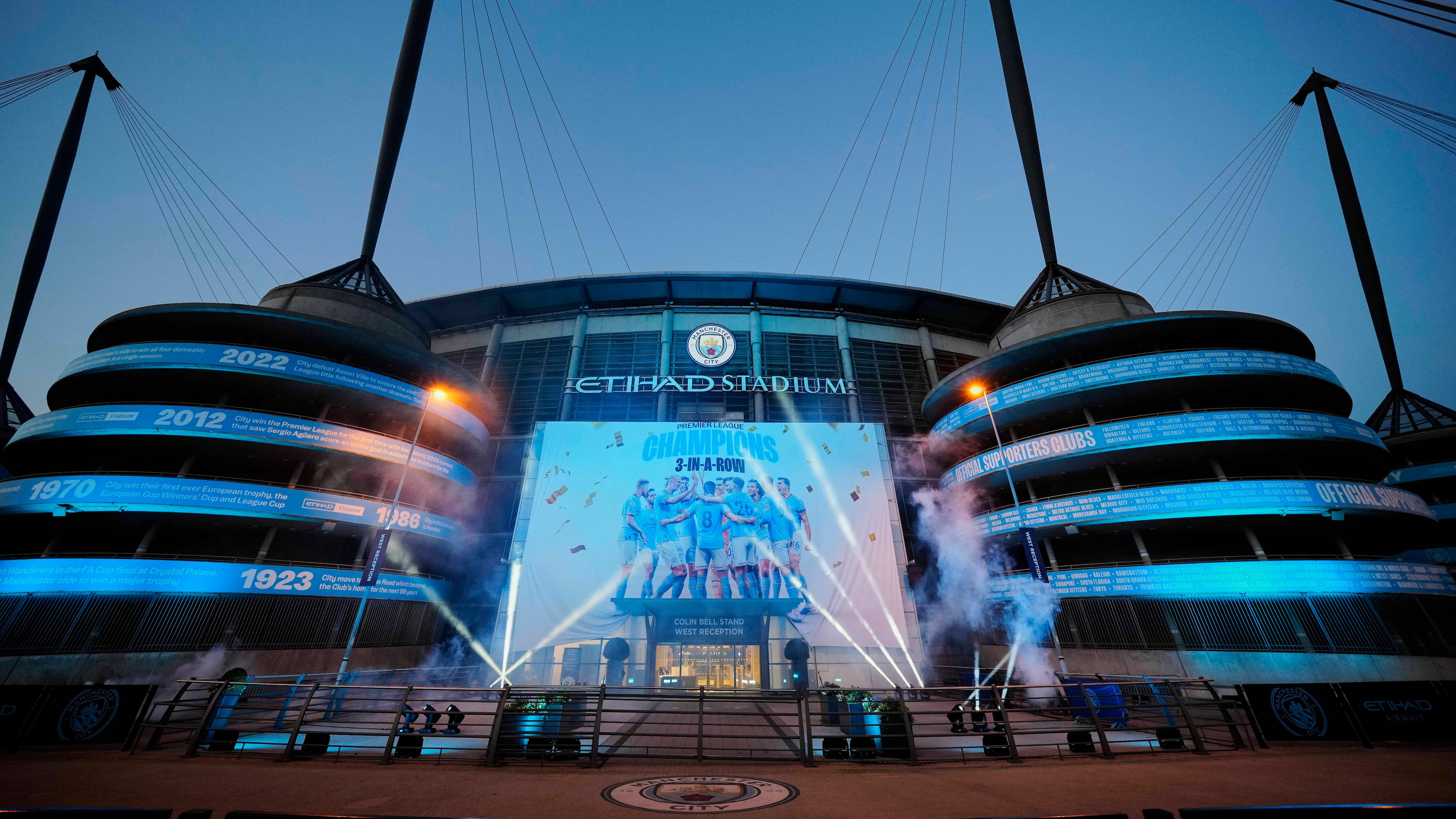 FILE - A banner celebrating their title win is illuminated outside Manchester City's Etihad stadium in Manchester, England, Saturday, May 20, 2023. (AP Photo/Jon Super, File)