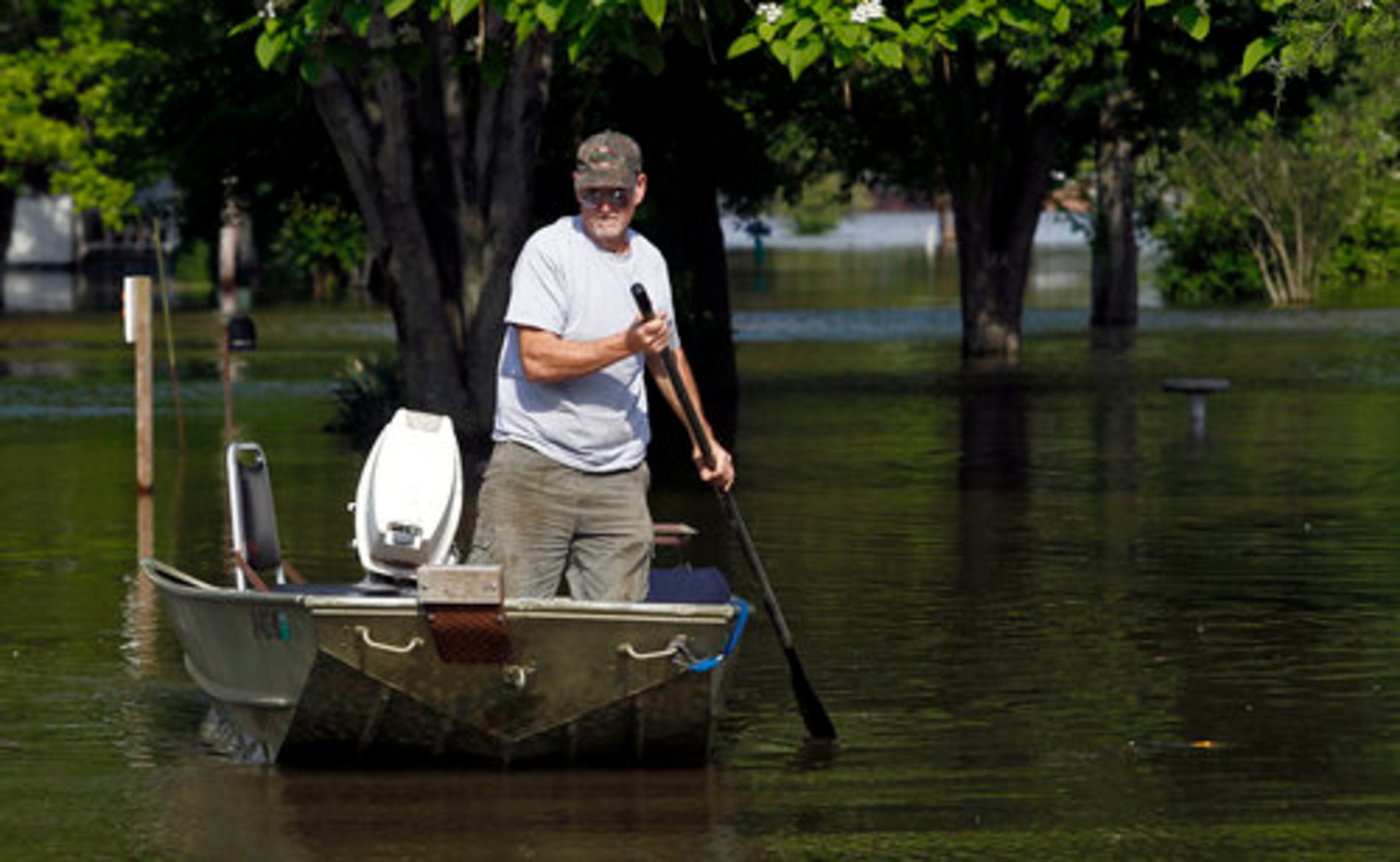 Joe Bledsoe paddles a boat through his neighborhood Saturday, May 7, 2011 in Bogota, Tenn.