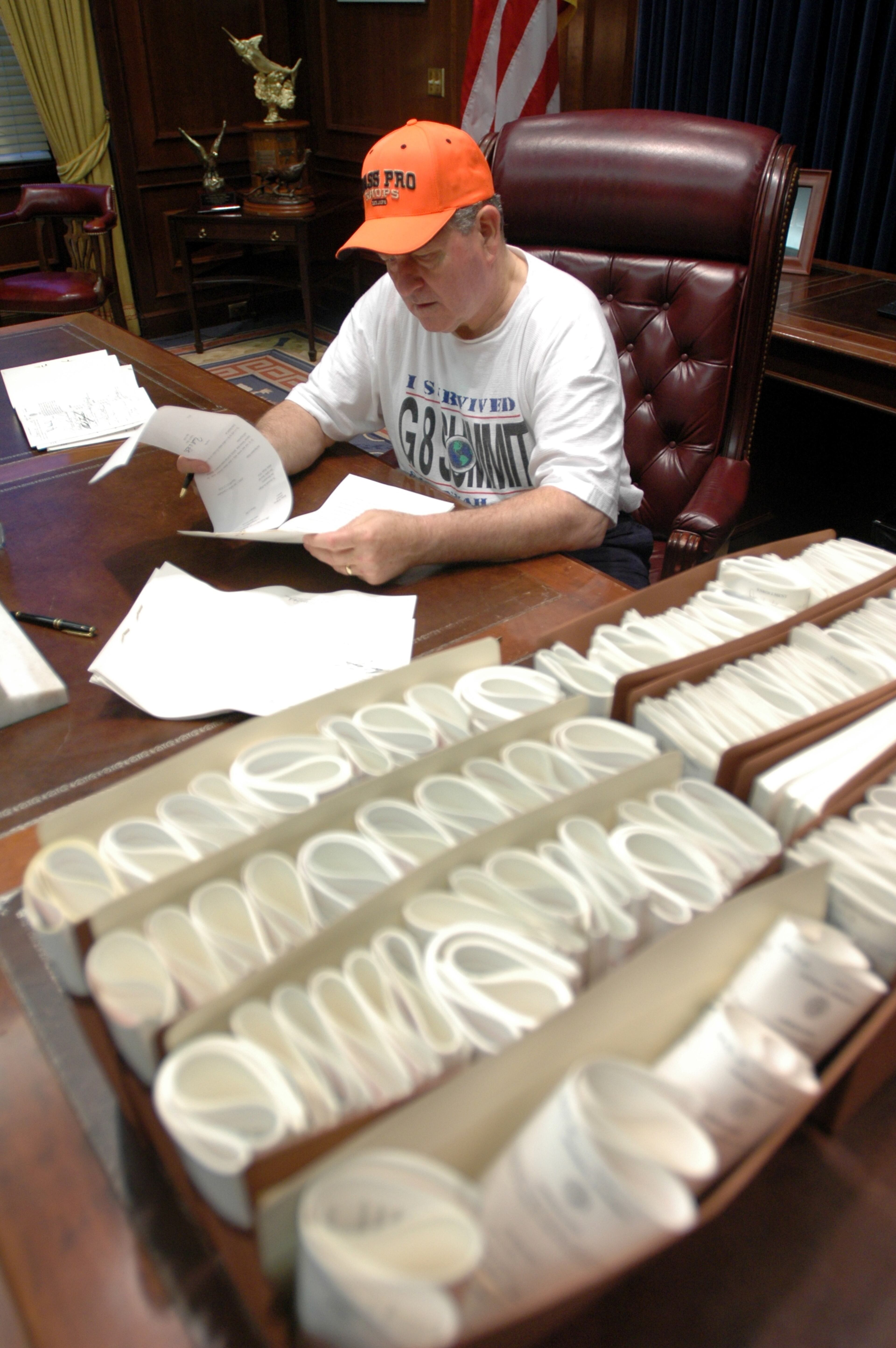 050408-ATLANTA-Fresh from his morning racquetball game, Gov. Sonny Perdue (cq) look over one of the 10 bills he signed into law early Friday morning to start his day in the Governor's office of the Capitol. The stack of bills in the foreground are just the beginning of the hundreds of bills he must review and decide whether to sign or veto before May 10th, the 40th and final day for him to act on a bill before it becomes law by default. Perdue will spend much of his free time for the next few weeks signing the laws that don't call for ceremony and fanfare. (BEN GRAY/STAFF) ben's cell 404-964-9686