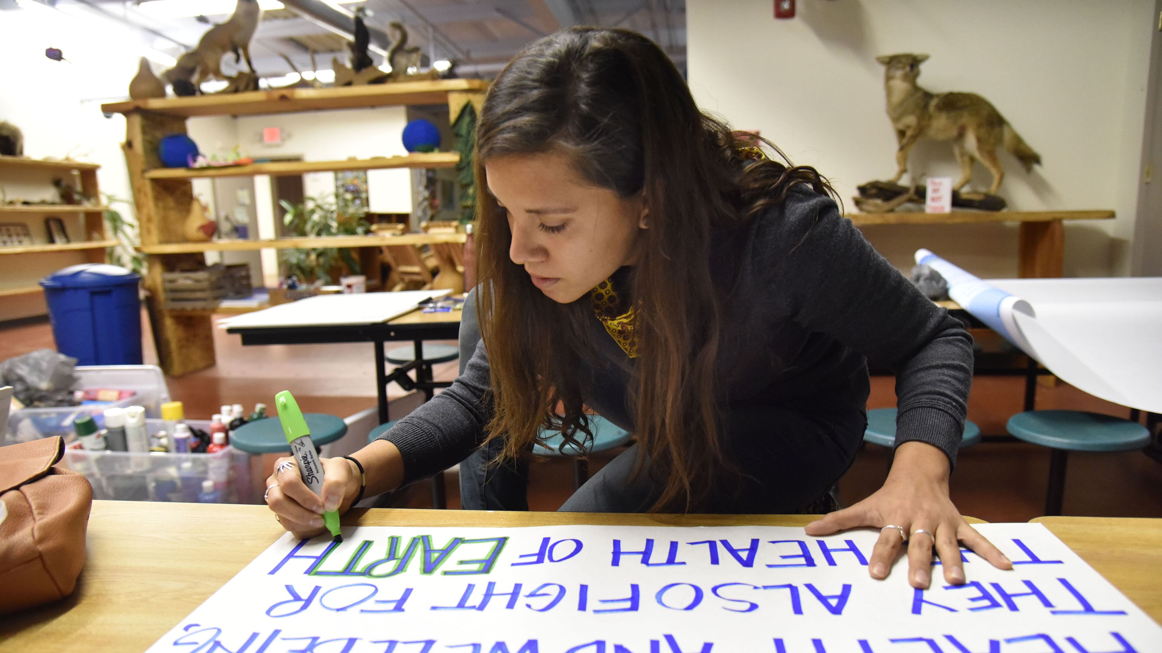 Marinangeles Gutierrez, who plans to go Washington, DC for Women’s March on Saturday, Jan, 21, writes her message during a sign-making session at the Sierra Club of Georgia. HYOSUB SHIN / HSHIN@AJC.COM