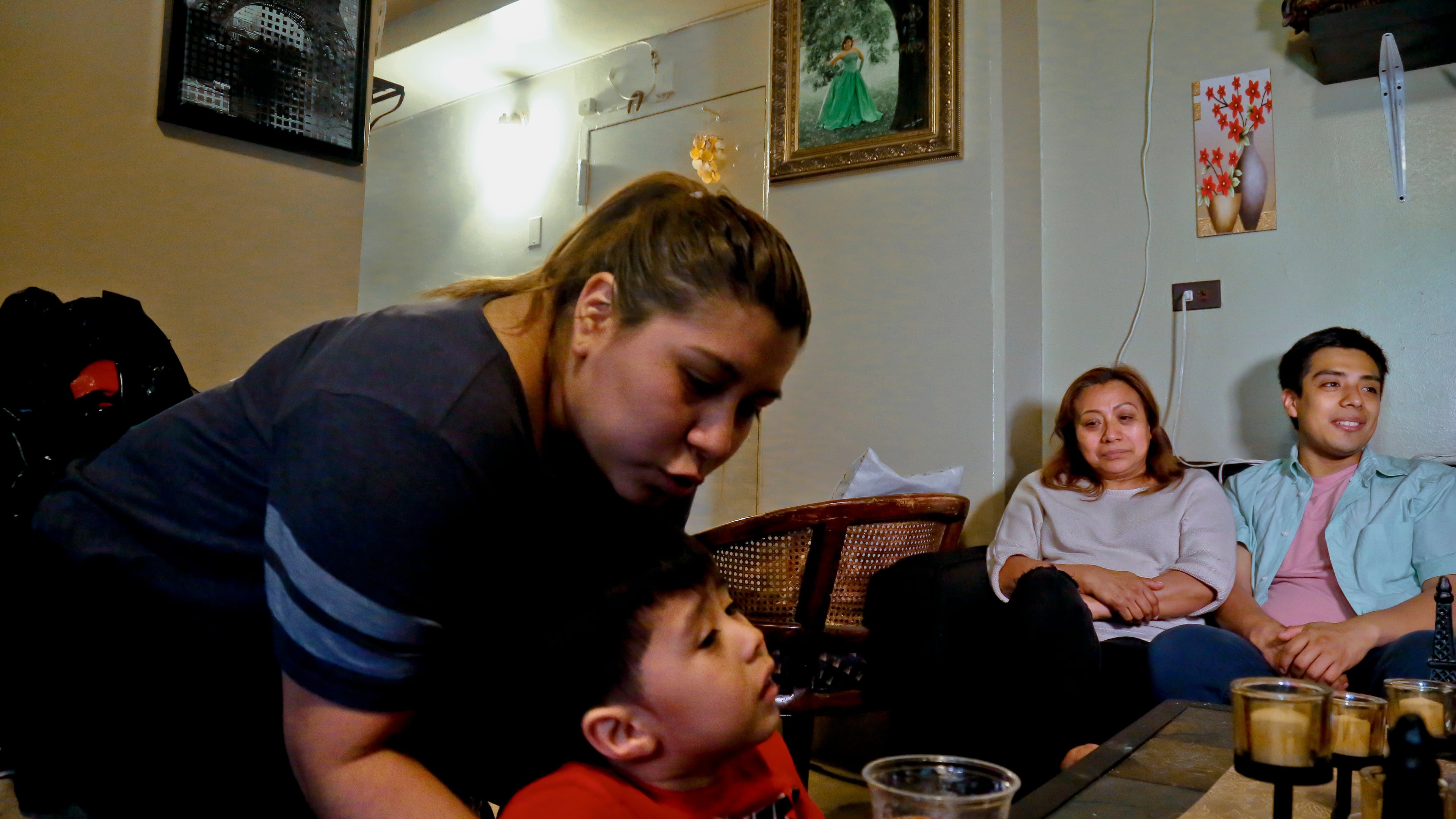 FILE PHOTO - Rosa, second from right, who wants her last name withheld, an undocumented immigrant who used to get about $190 per month from the Supplemental Nutrition Assistance Program, or SNAP, and who stopped taking benefits fearing deportation, is surrounded by her son Edgar, far right, daughter Olga, far left, and grandson Logan at their home during an interview in New York, May 17, 2017. (AP Photo/Bebeto Matthews, File)