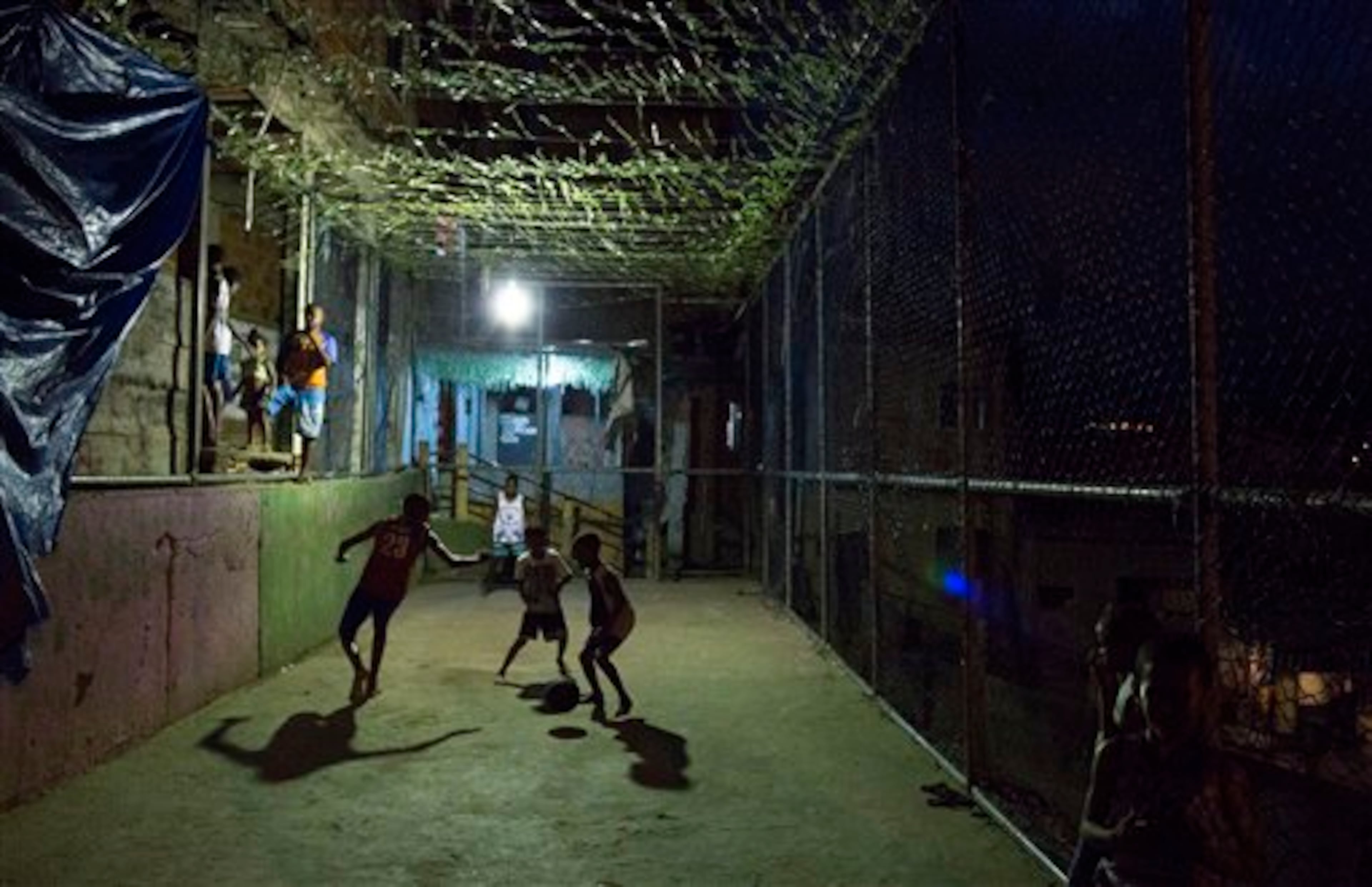 In this Monday, June 2, 2014 photo, youth play soccer in the Mangueira slum of Rio de Janeiro, Brazil. "I would like to watch a final match between Brazil and Portugal because I'm a fan of Brazil's Neymar and Portugal's Cristiano Ronaldo," said 13-year-old Alex Silva, a Mangueira resident. "But I know I won't get to because I don't have money to buy a ticket." (AP Photo/Leo Correa)