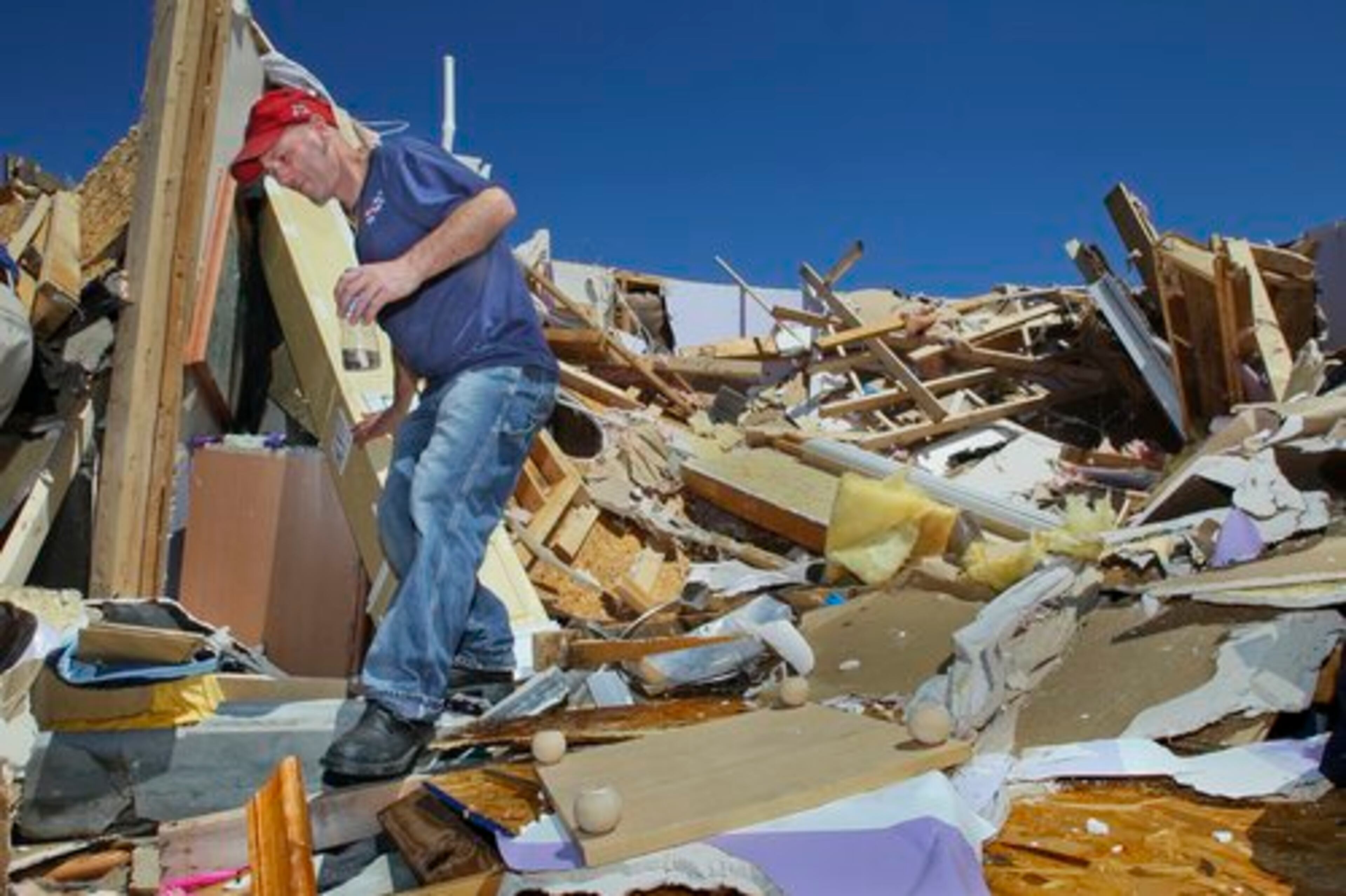Joe Machado leaves the area where he pulled his wife, Zel, out of their home's collapsed upper floors. The couple and their special-needs child, Breana, 12, survived the storm in Brooks.
