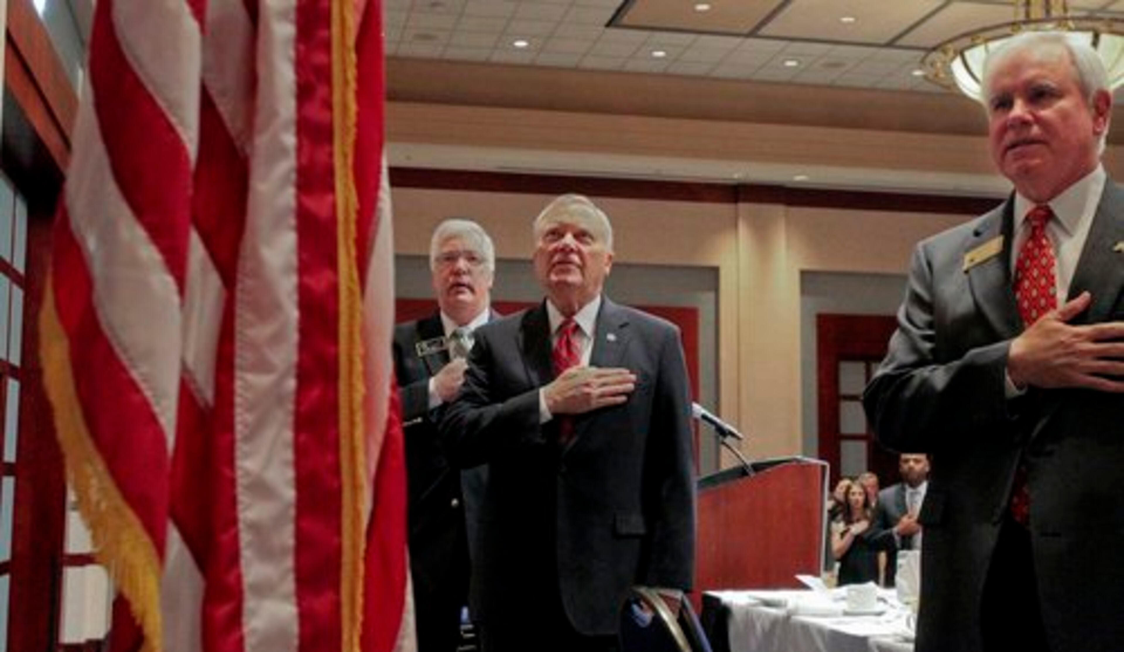 Tim Lee, chairman of the Cobb County Board of Commissioners, Gov. Nathan Deal and Gary Davis, with Wells Fargo, say the Pledge of Allegiance before the breakfast began Monday.