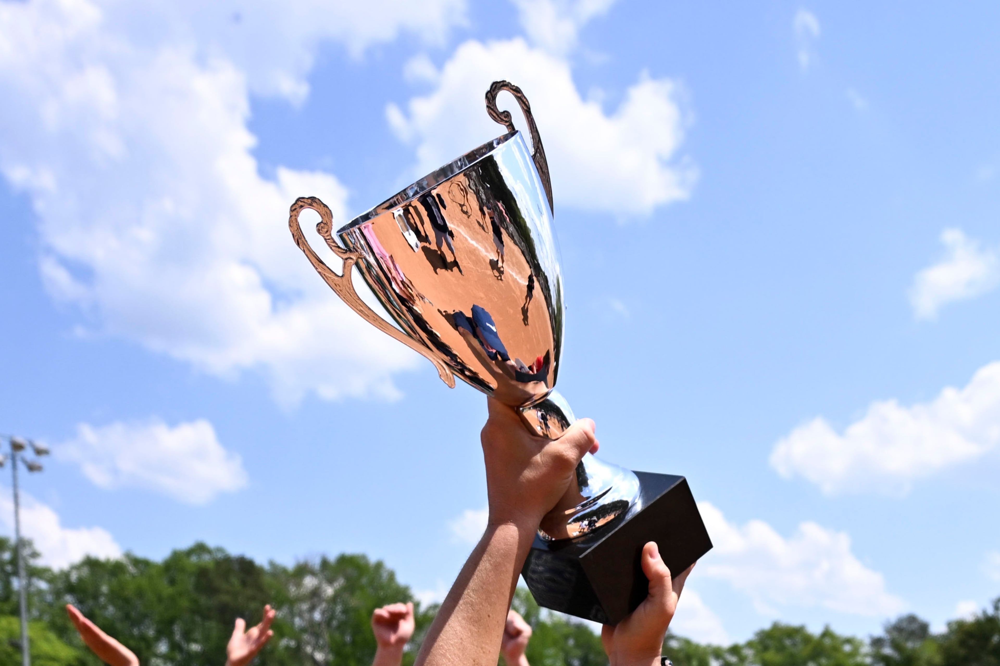 Creekview head coach Jennifer Maloney holds her GHSA championship trophy high Thursday, April 23, 2026, after beating Cherokee in a slow pitch softball game at Twin Creeks Softball Complex. (Daniel Varnado for the AJC)