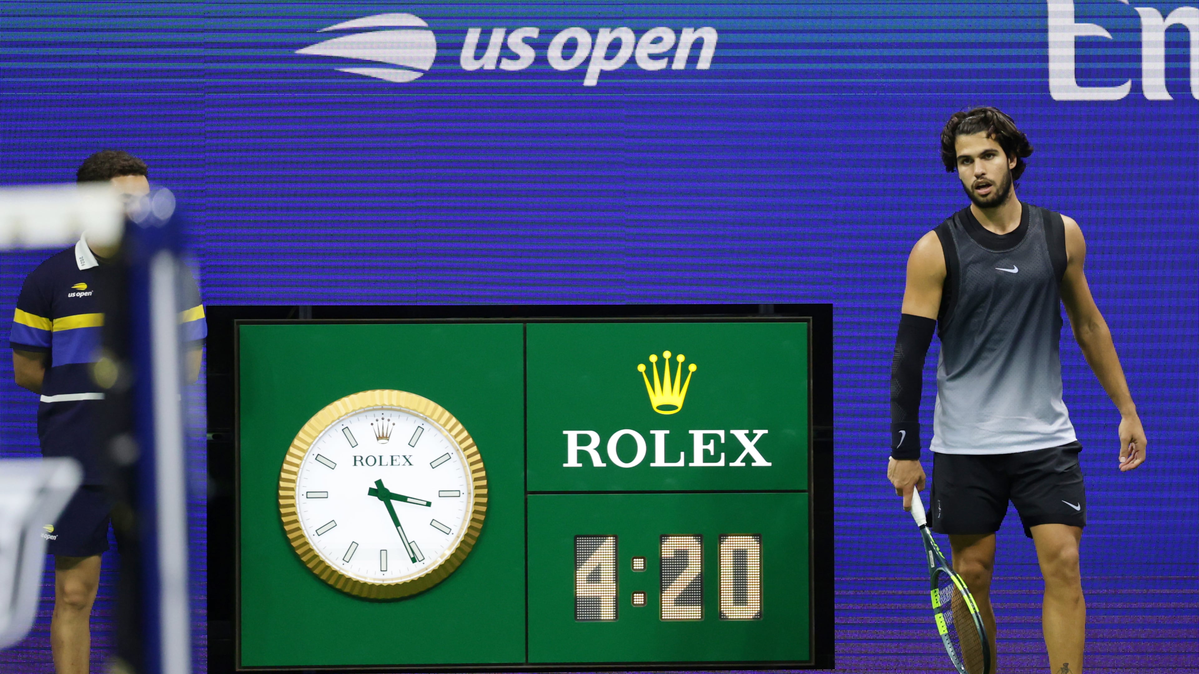 The clock reads 3:21 a.m. as Carlos Alcaraz, of Spain, plays in the fifth set against Ben Shelton, of the United States, during the quarterfinal round of the U.S. Open tennis championships, early Wednesday, Sept. 9, 2026, in New York. (AP Photo/Adam Hunger)