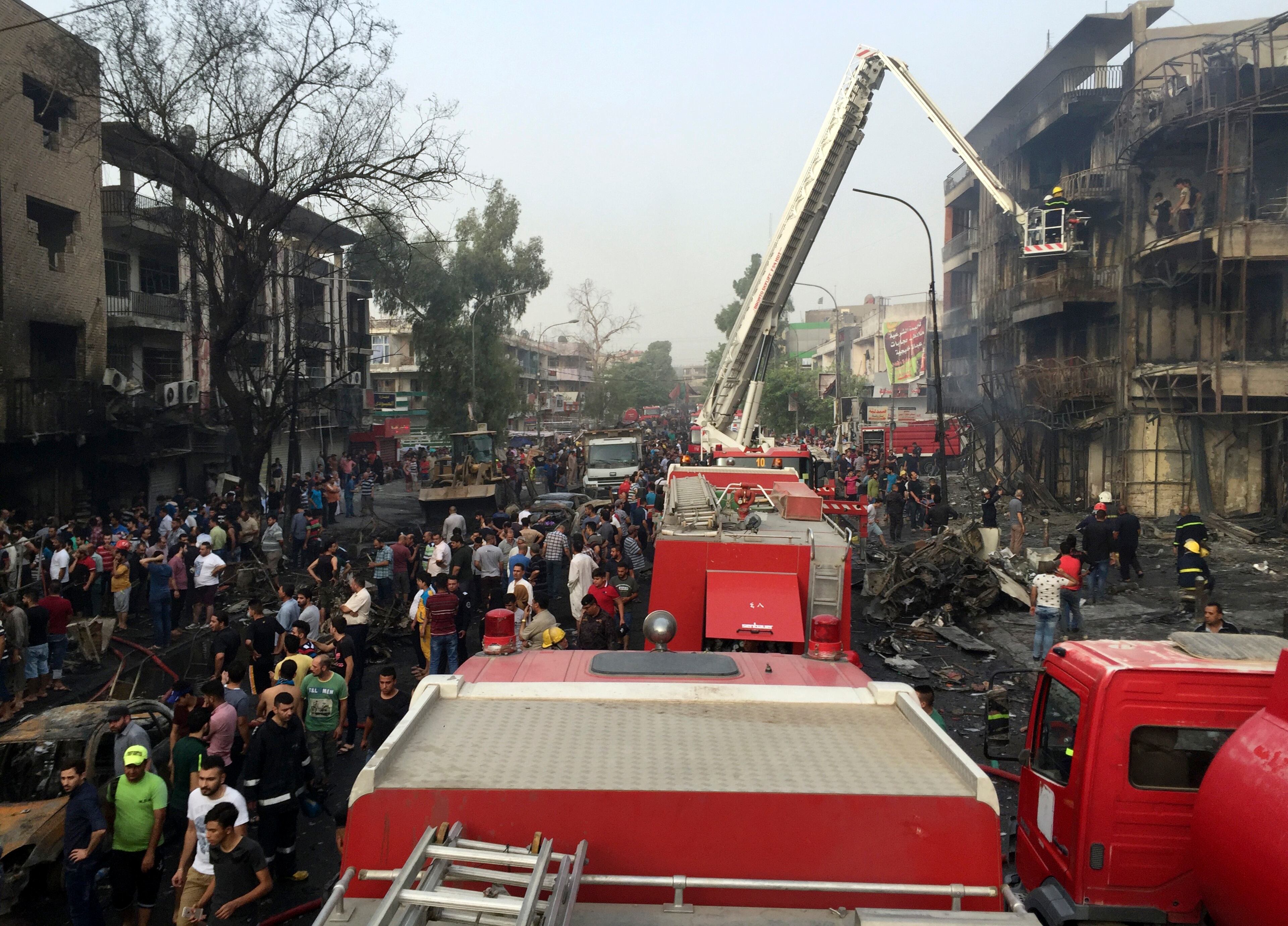 Iraqi security forces look for victims as civilians gather at the site after a car bomb at a commercial area in Karada neighborhood, Baghdad, Iraq, Sunday, July 3, 2016. Bombs went off early Sunday in two crowded commercial areas in Baghdad. (AP Photo/Khalid Mohammed)
