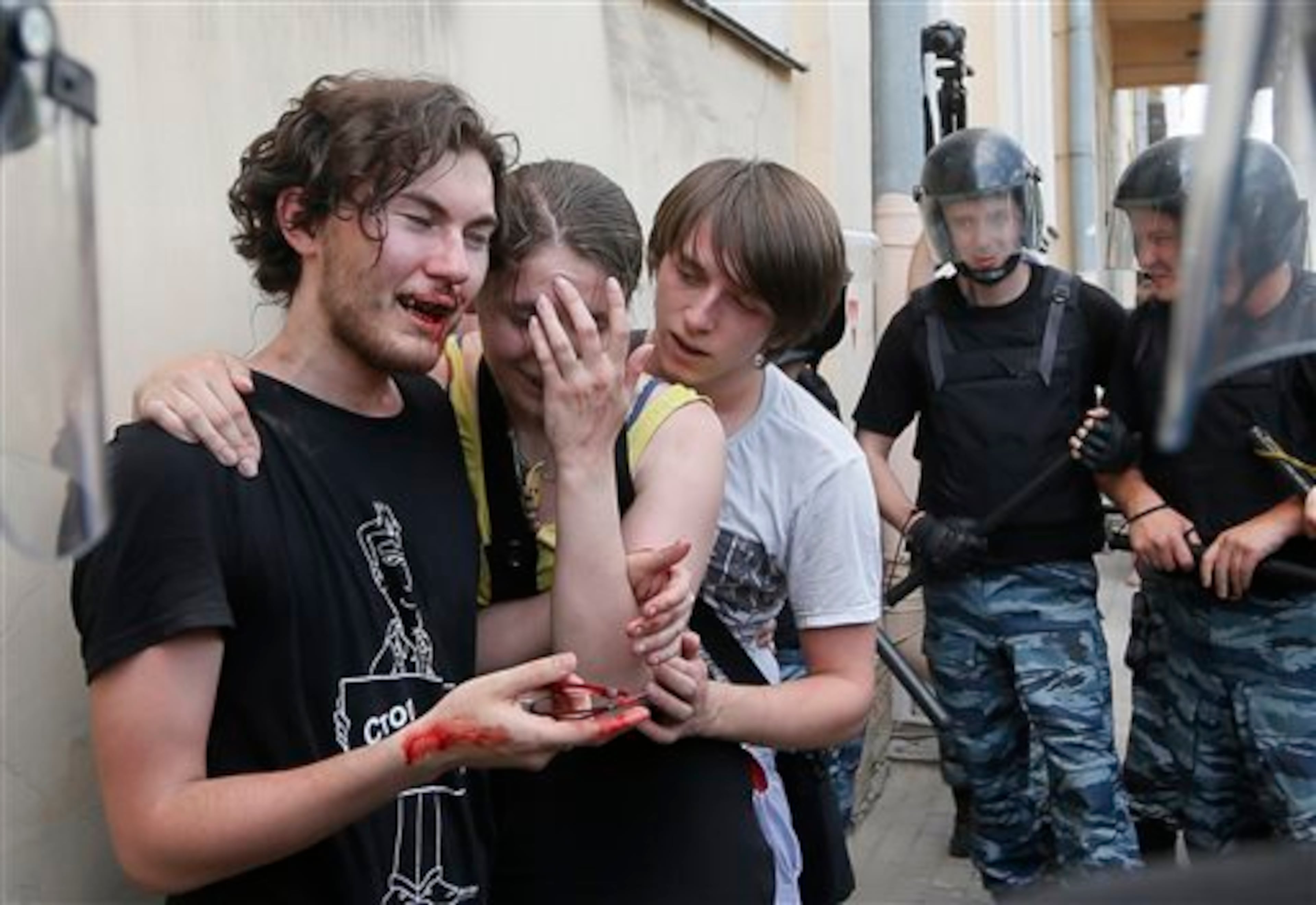 FILE - Riot police (OMON) guard gay rights activists who have been beaten by anti-gay protesters during an authorized gay rights rally in St.Petersburg, Russia, Saturday, June 29, 2013. Police detained several gay activists, who were outnumbered by the protesters. Dozens of gay activists had to be protected by police as they gathered for the parade, which proceeded with official approval despite recently passed legislation targeting gays. This image was chosen by the Associated Press as one of the top 10 news photos representing the top stories of 2013. (AP Photo/Dmitry Lovetsky, File)