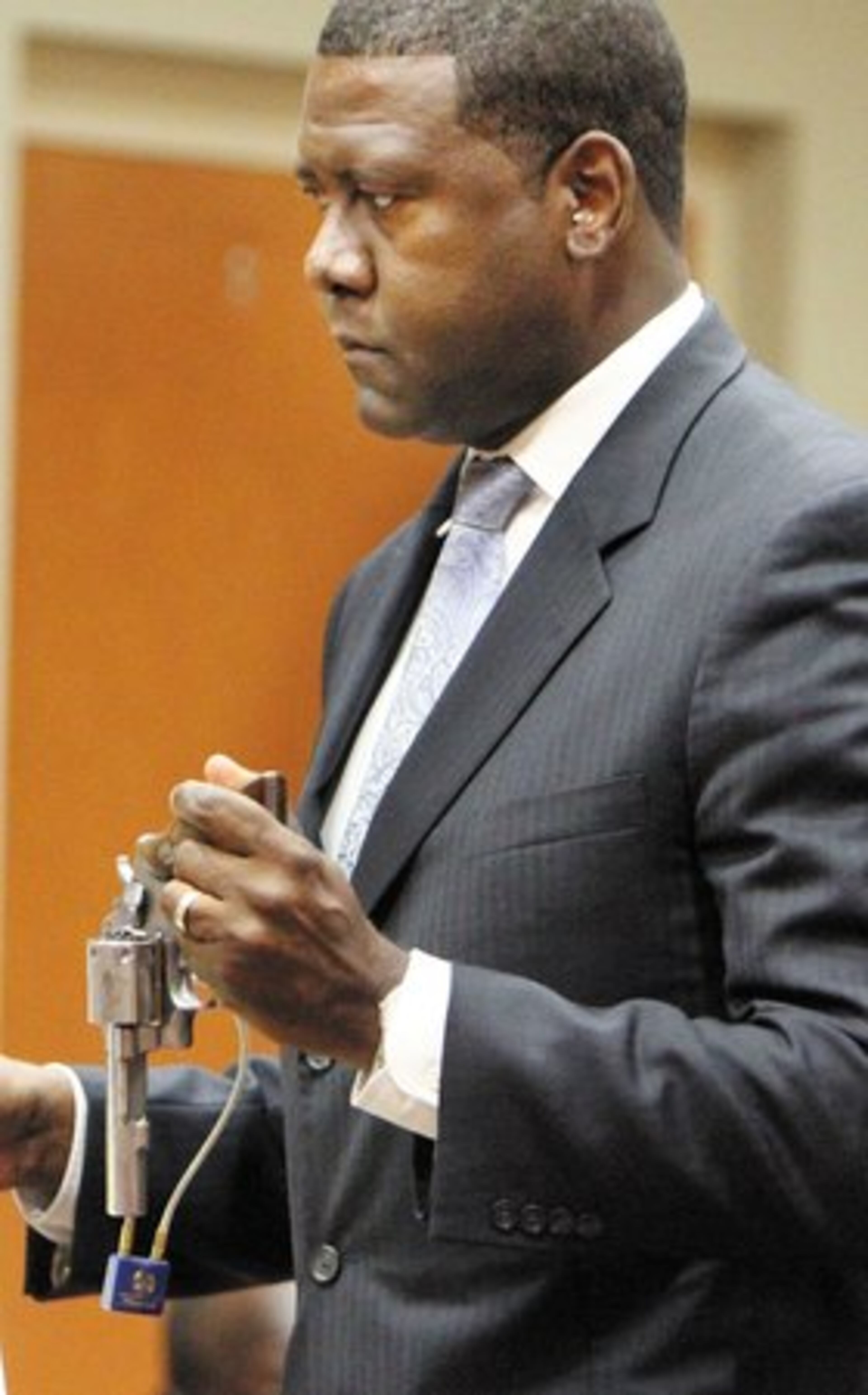 Prosecutors said Yancey lied to police, cut off his ankle monitor and then fled to Belize. Assistant District Attorney Ken Hutcherson shows the jury a hand gun believed to be the murder weapon.