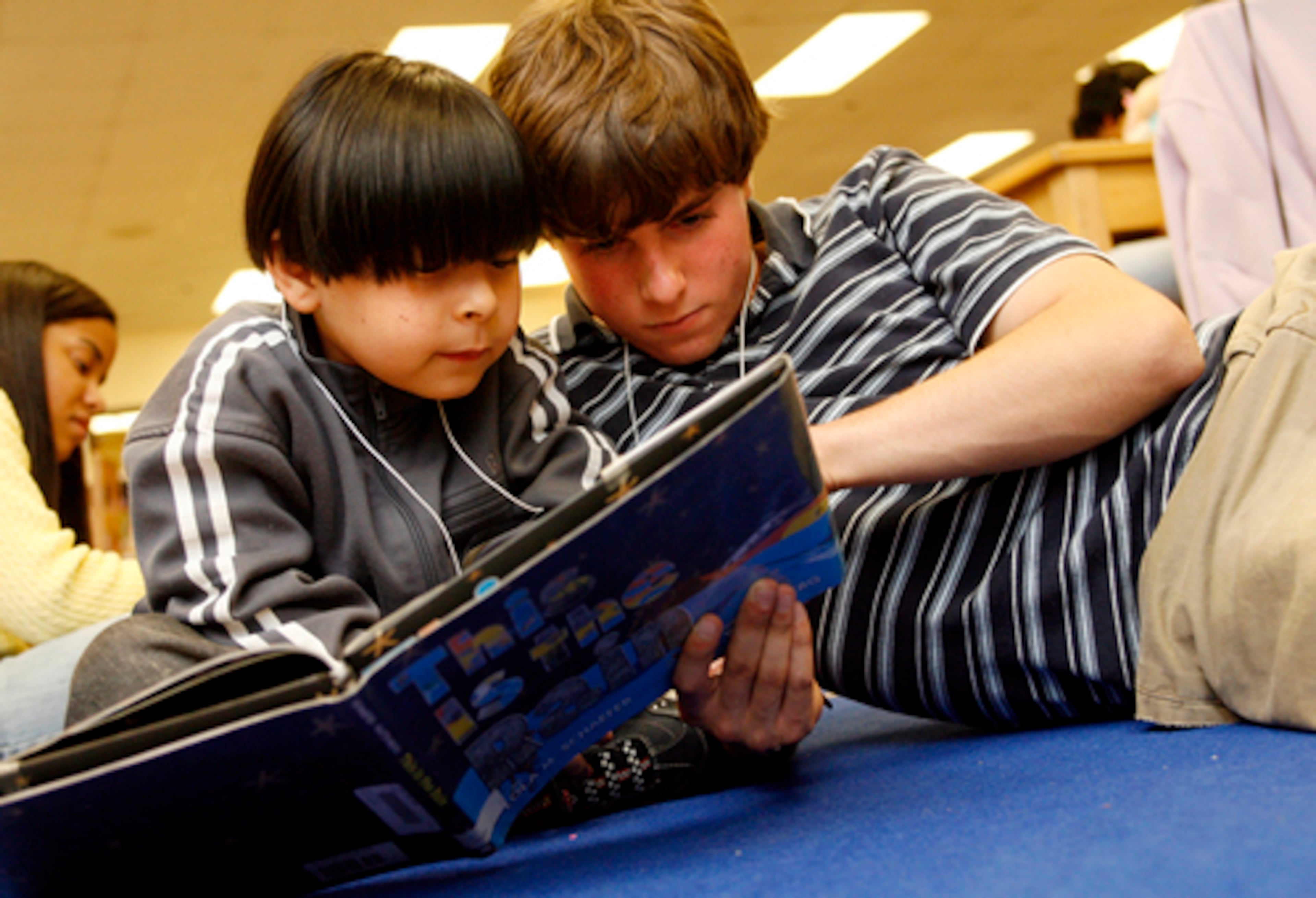 In an evening tutoring program called Wiz Kids, 6-year-old Miguel Castillo (left) reads with volunteer Scott Reed.