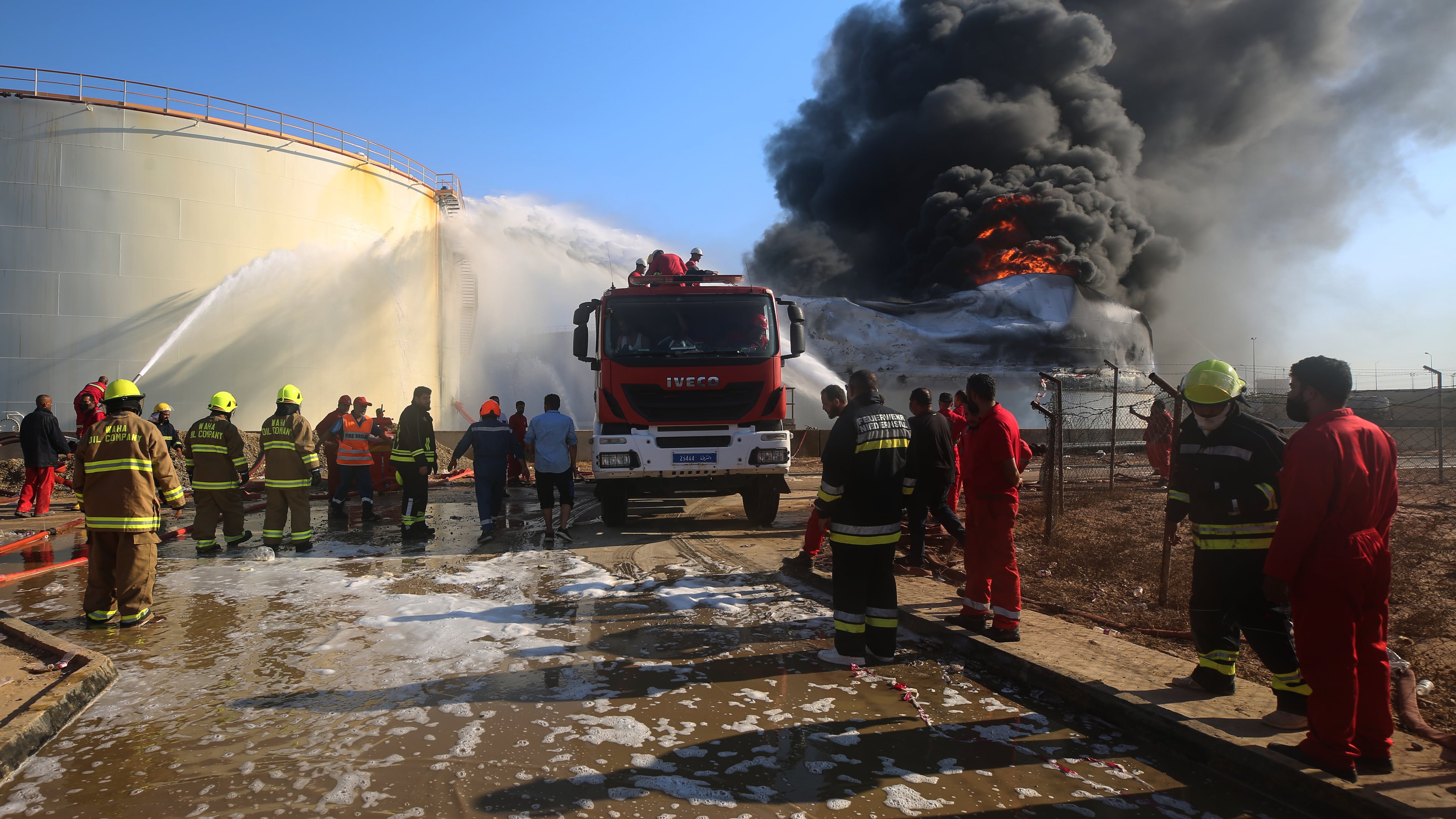 Firefighters work to contain a fire at the Zawiya oil refinery following a drone strike in Zawiya, Libya, Tuesday, Aug. 11, 2026. (AP Photo/Yousef Murad)