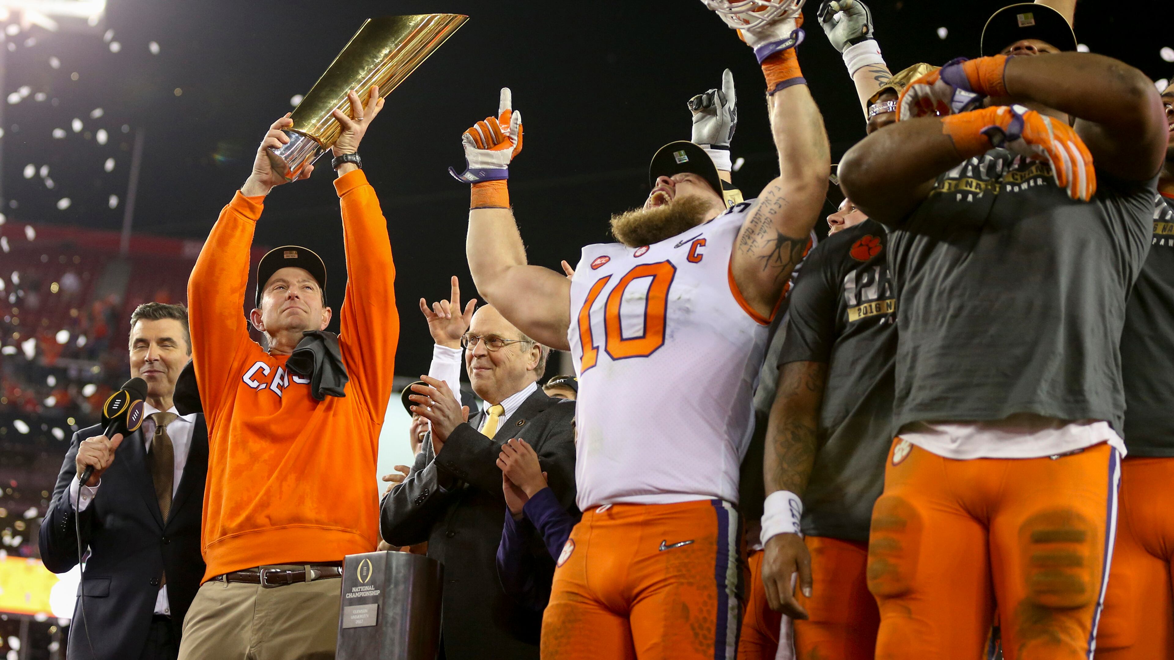 Clemson Tigers head coach Dabo Swinney, left, holds the College Football Playoff National Championship trophy while he and his team celebrate their 35-31 win over the Alabama Crimson Tide Monday, Jan. 9, 2017 in Tampa, Fla. (Loren Elliot/Tampa Bay Times/TNS)