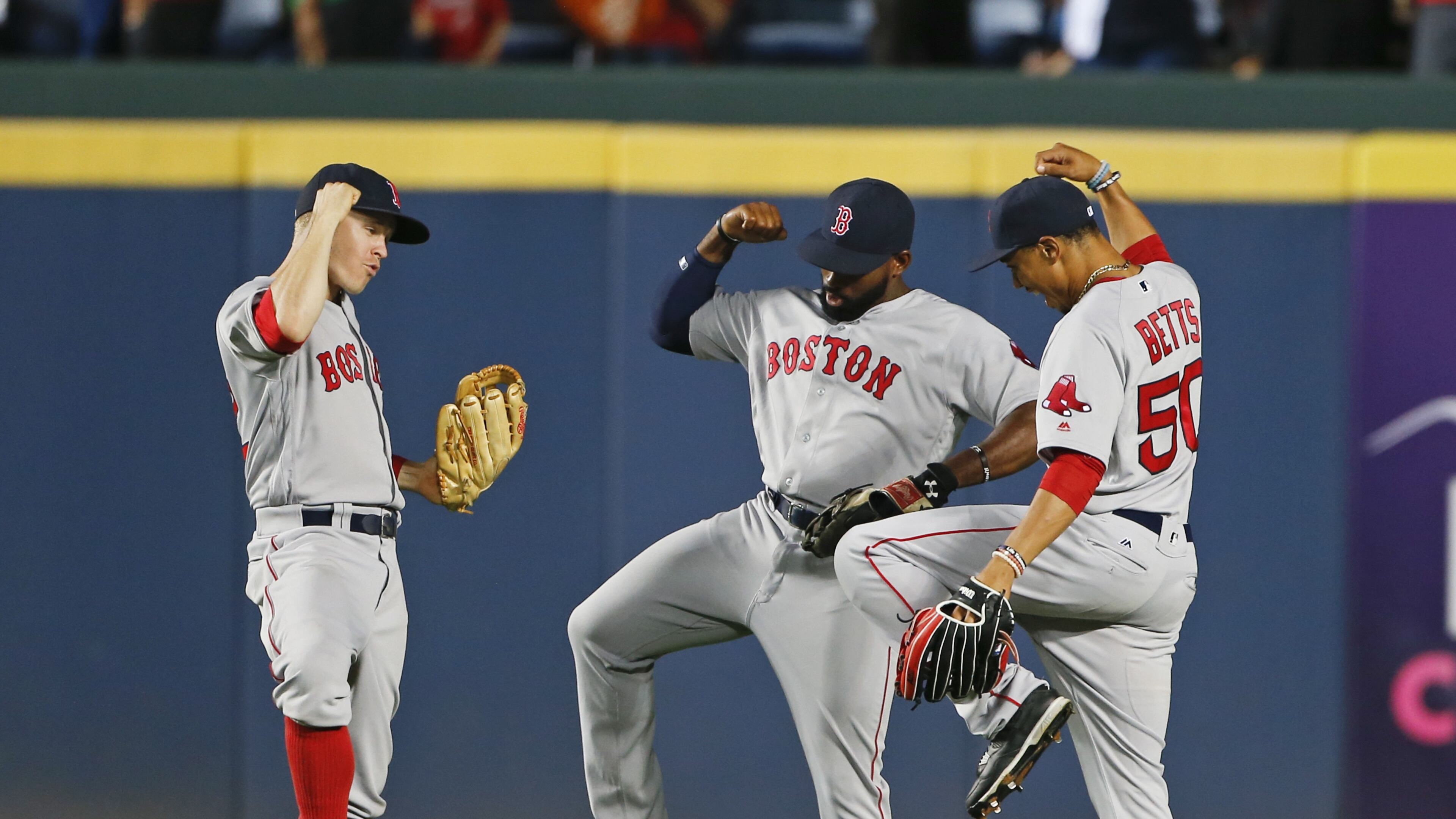 Boston Red Sox outfielders, from left, left fielder Brock Holt (12), center fielder Jackie Bradley Jr. (25) and right fielder Mookie Betts (50) celebrate after defeating the Atlanta Braves, 1-0, in a baseball game Monday, April 25, 2016, in Atlanta. Bradley scored the game's only run with a solo-home run in the seventh inning. (AP Photo/John Bazemore)