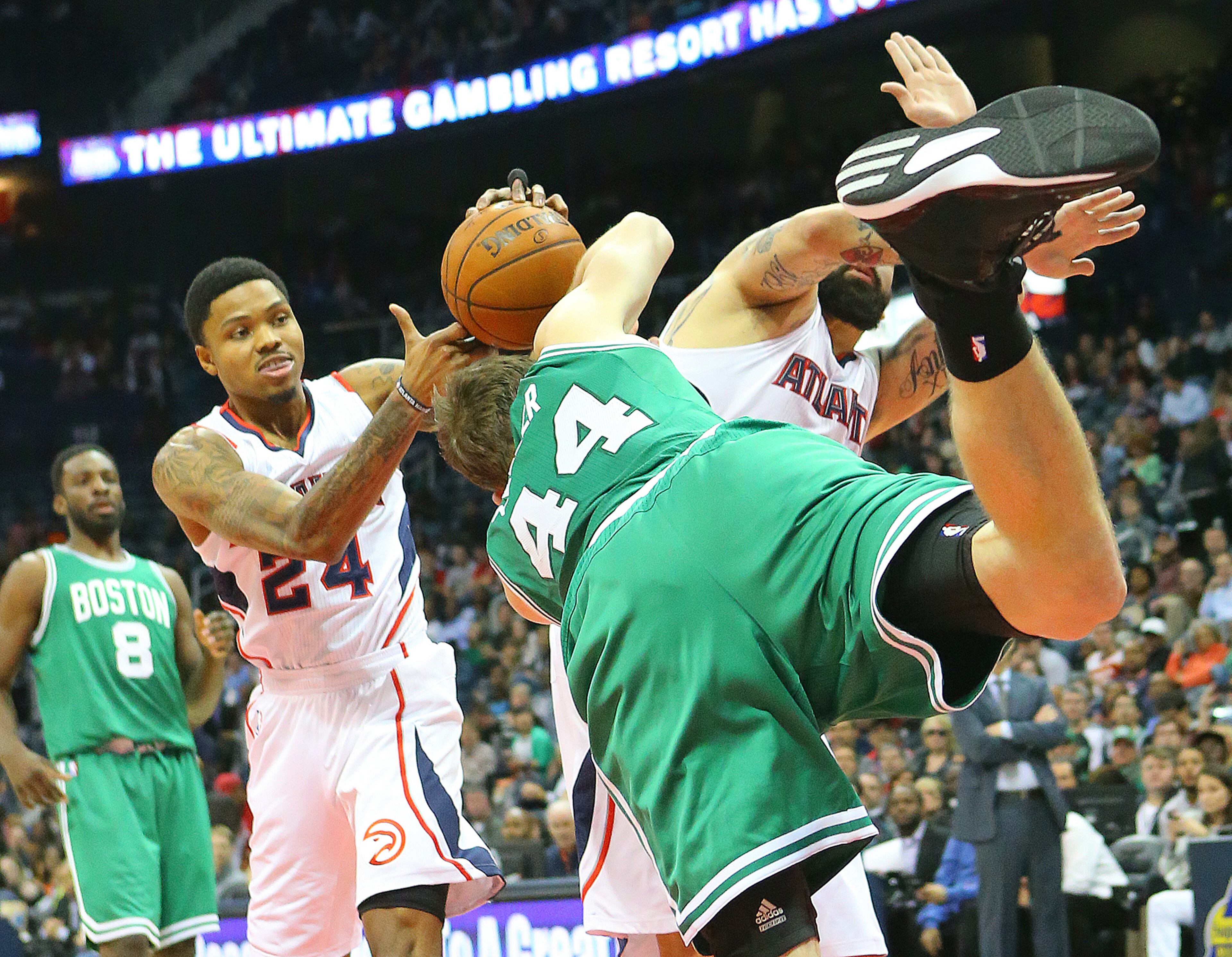 Hawks guard Kent Bazemore battles Celtics center Tyler Zeller for the ball under the basket during the first half in an NBA basketball game on Tuesday, Dec. 2, 2014, in Atlanta. CURTIS COMPTON / CCOMPTON@AJC.COM