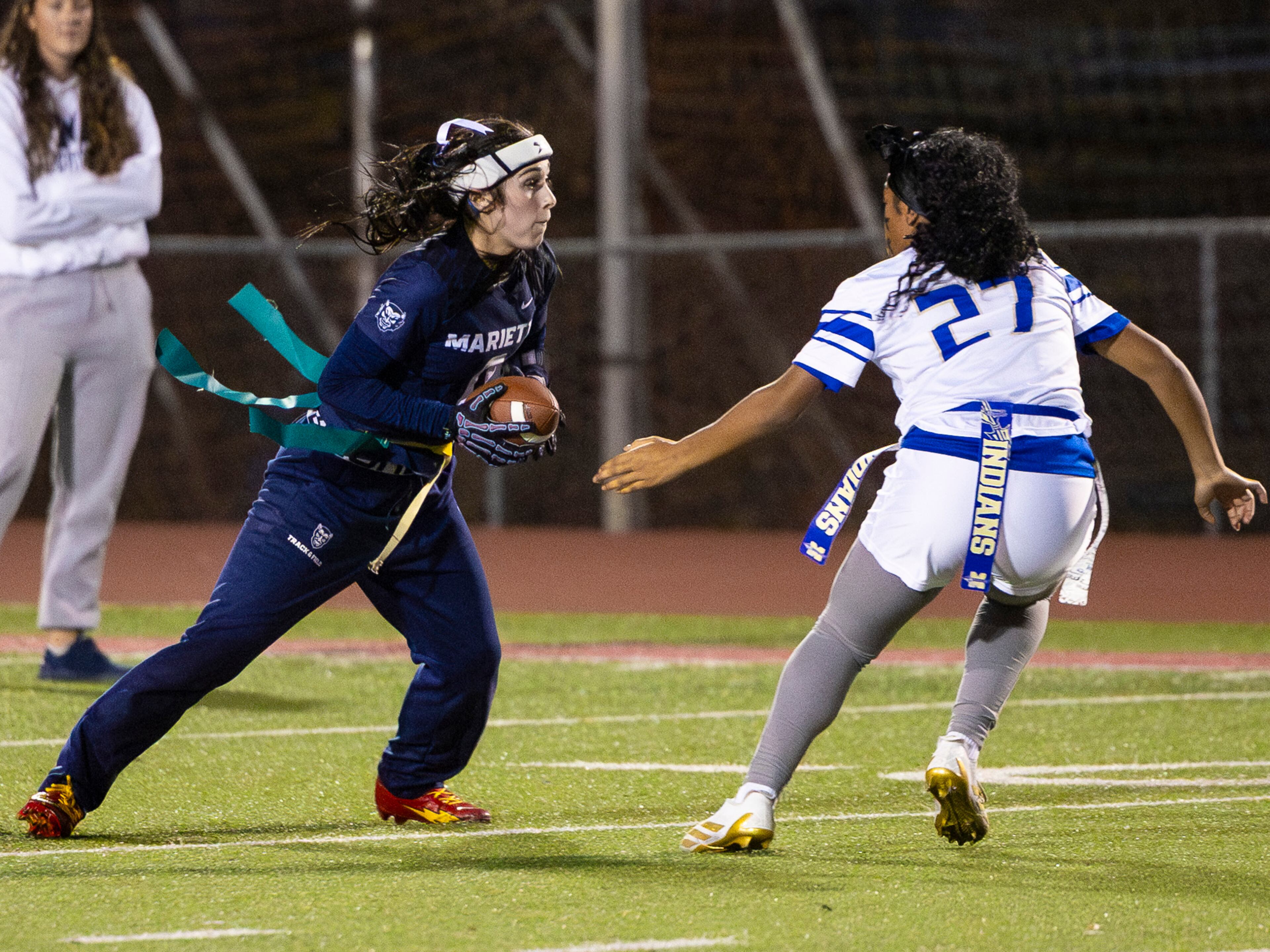 Marietta's Aksana Corey (left) runs with the ball in a flag football game against McEachern at Osborne High School in Marietta, GA on Monday, November 17th, 2025. (Oscar Guevara Saenz for the AJC)