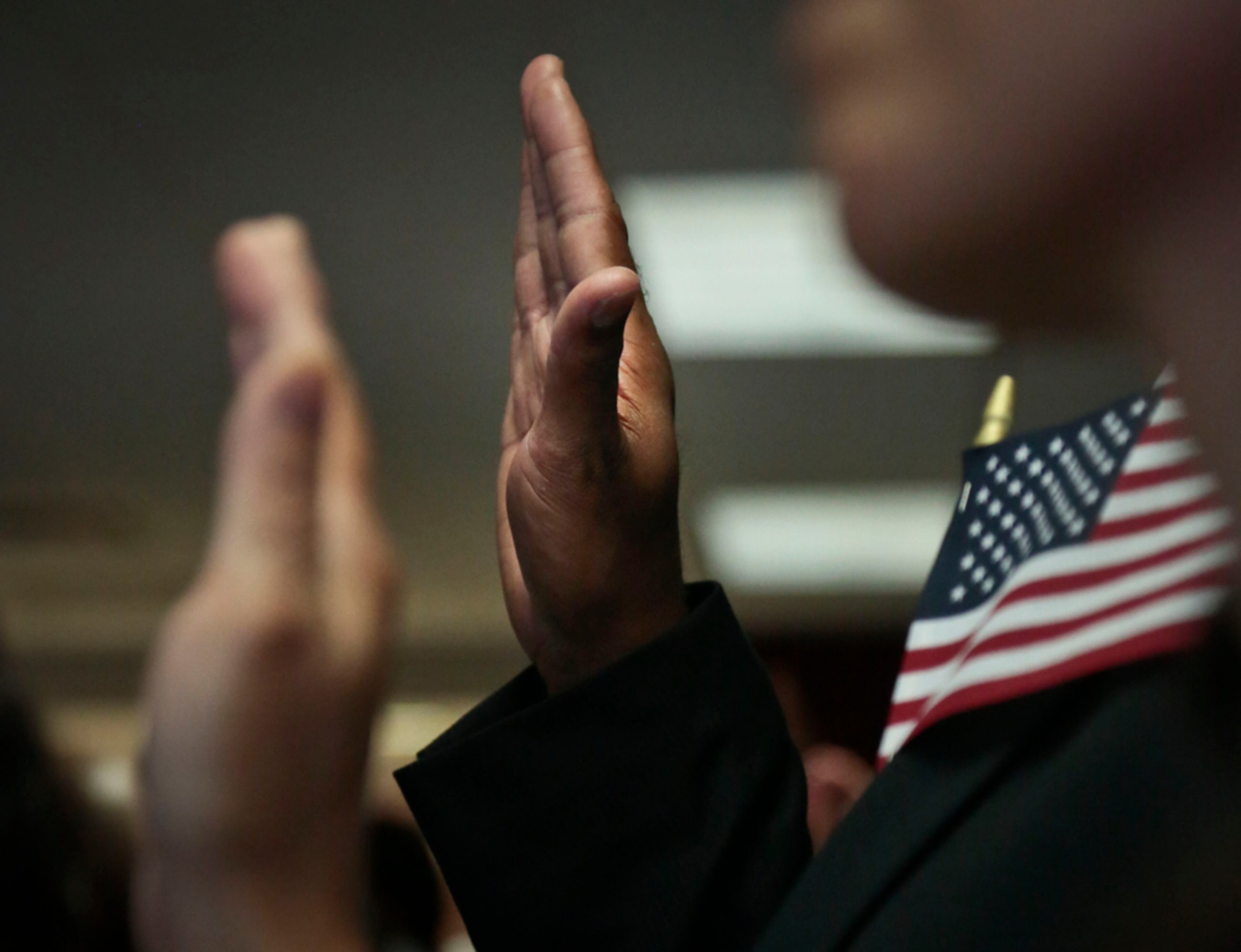 BECOMING A CITIZEN--New citizens raise their hands during the oath of allegiance, during a naturalization ceremony at the U.S. Citizenship and Immigration Services (USCIS) on Tuesday, July 2, 2013, in New York. Four hundred and fifty people were sworn in as citizens during three ceremonies throughout the day to mark the July 4th observance. Across the country, 7,800 people will become citizens at similar ceremonies this week. (AP Photo/Bebeto Matthews)
