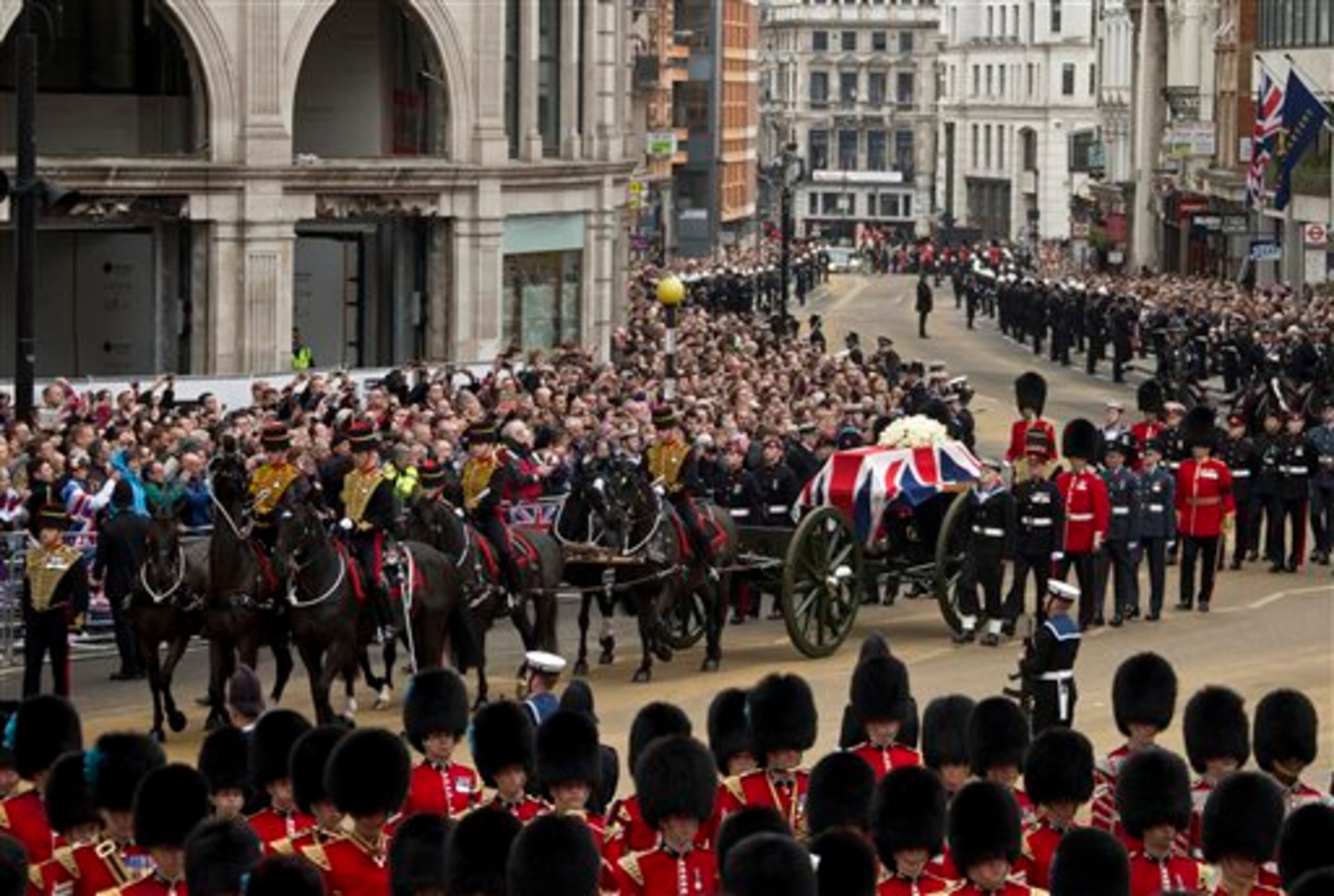A Union flag draped coffin bearing the body of former British Prime Minister Margaret Thatcher is carried on a gun carriage drawn by the King's Troop Royal Artillery during her ceremonial funeral procession in London, Wednesday, April 17, 2013. A coffin containing the body of former Prime Minister Margaret Thatcher was driven Wednesday from the Houses of Parliament to the church of St. Clement Danes for prayers ahead of the former leader's full funeral at St. Paul's Cathedral. (AP Photo/Joel Ryan, Pool)