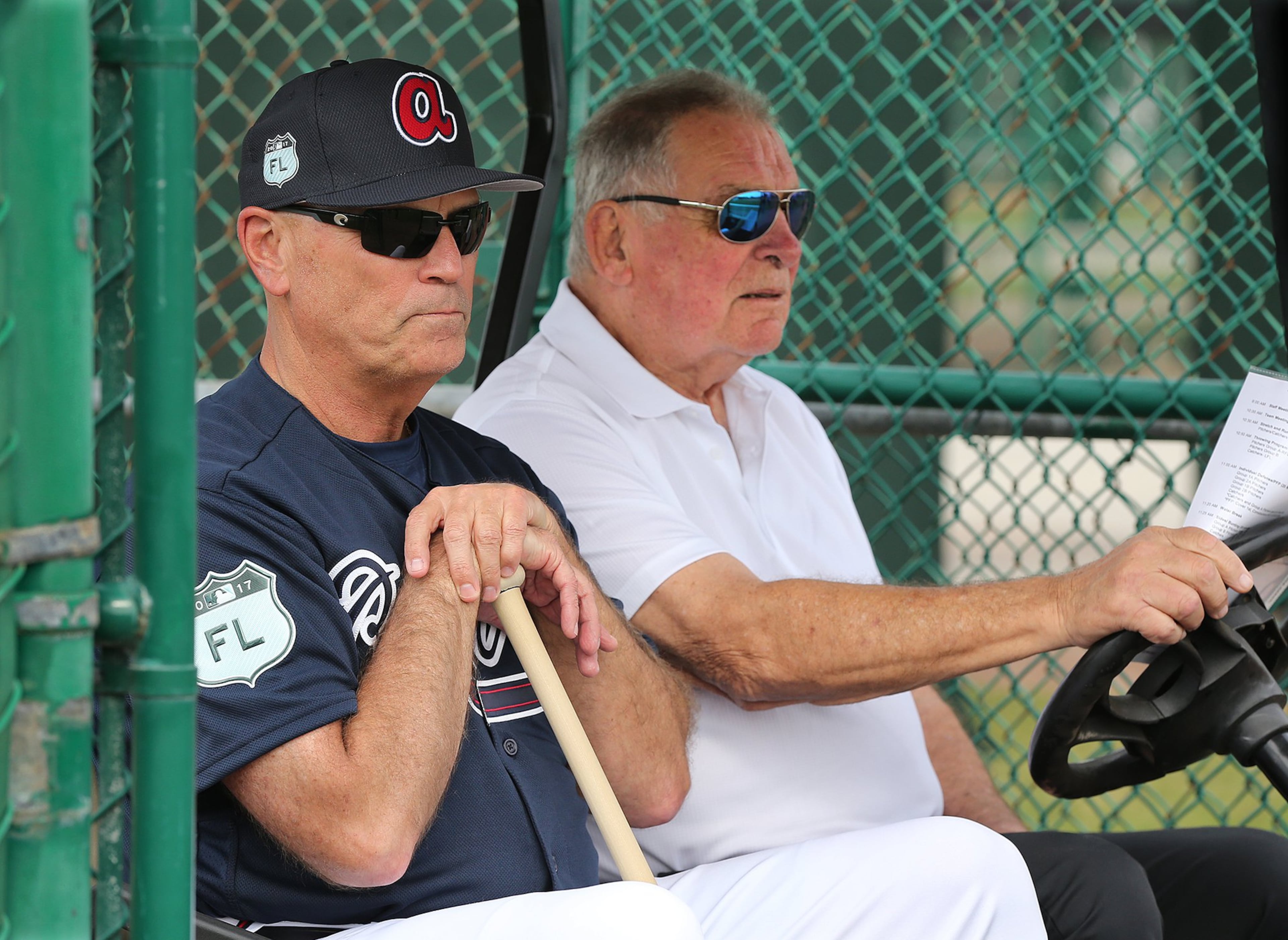 Braves manager Brian Snitker watches a spring-training workout seated next to his mentor, legendary former Braves manager Bobby Cox. (Curtis Compton/AJC file photo)