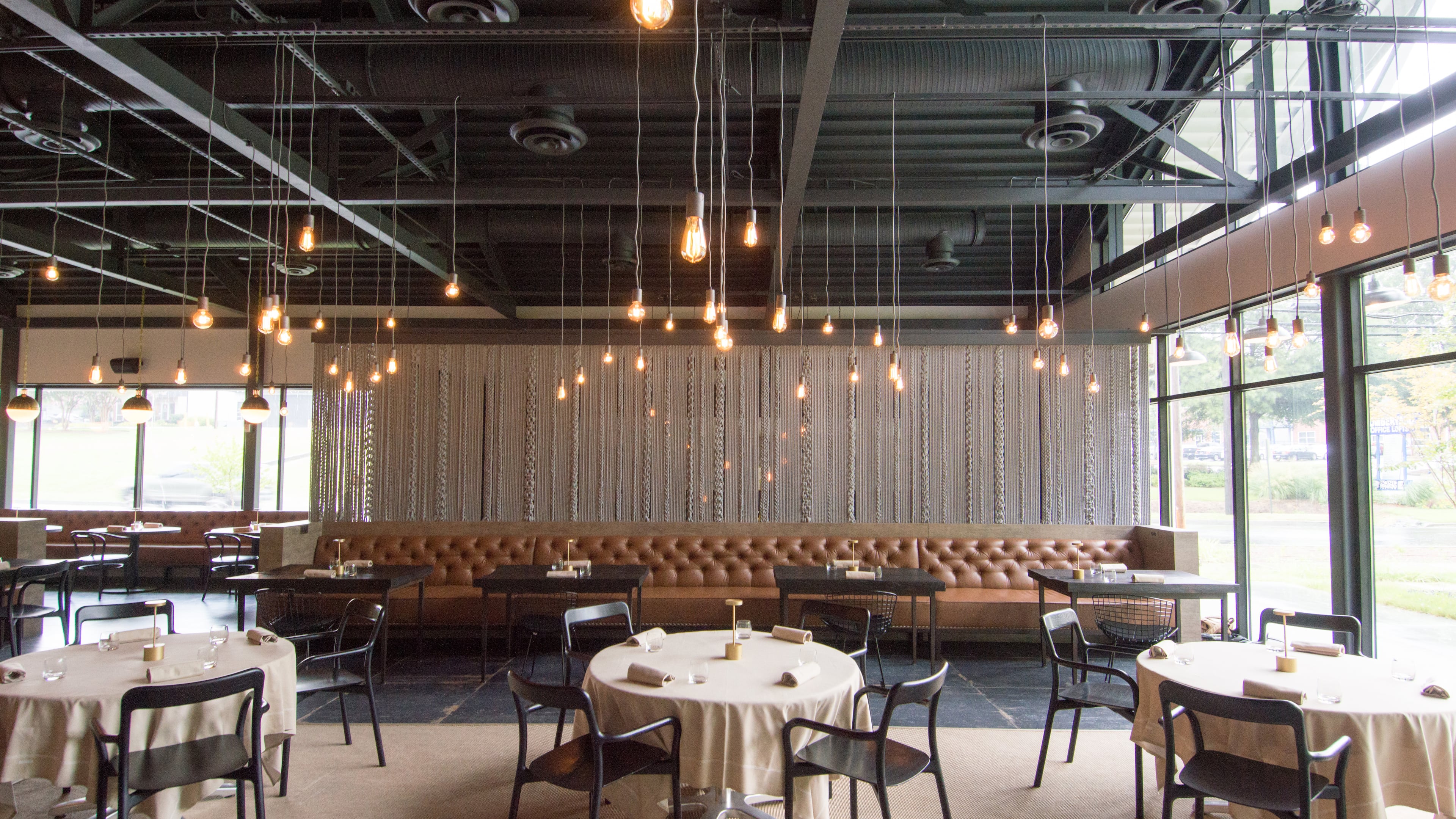 The main dining room at Bacchanalia is capped at one end with a wall of glass, bathing the space in natural light. CONTRIBUTED BY HENRI HOLLIS