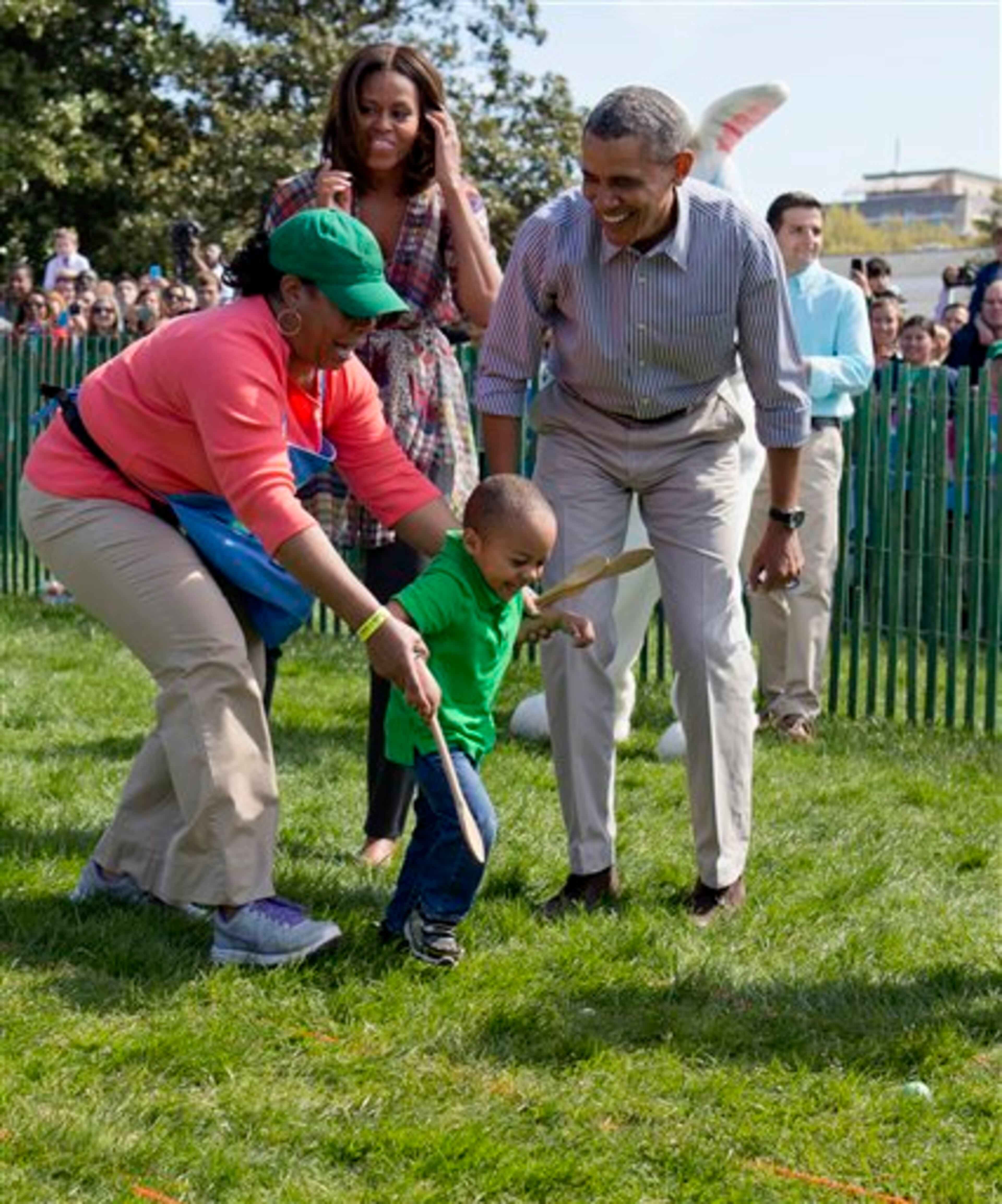 President Barack Obama and first lady Michelle Obama cheer a little egg roller as they host the White House Easter Egg Roll on the South Lawn of the White House is Washington, Monday, April 21, 2014. Thousands of children gathered at the White House for the annual Easter Egg Roll. This year's event features live music, cooking stations, storytelling, and of course, some Easter egg rolling. (AP Photo/Carolyn Kaster)