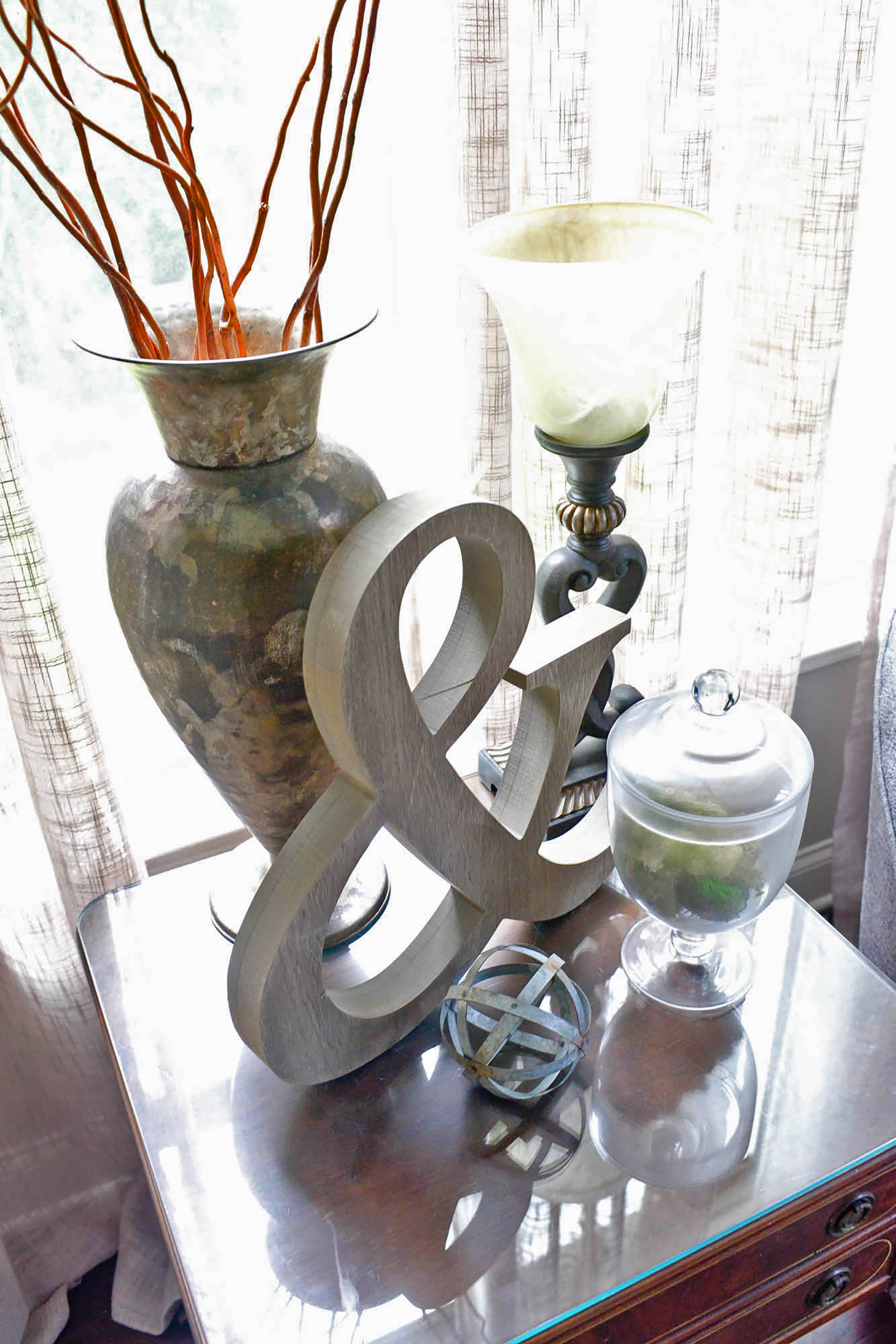 A metal ampersand is a versatile decor piece that works on shelves and side tables, like Leslie McCoy used in her Buford home. She paired the accessory with vases, candles and a sphere. Text by Lori Johnson and Kelsey E. Green/Fast Copy News Service.
(Christopher Oquendo Photography/www.ophotography.com)
