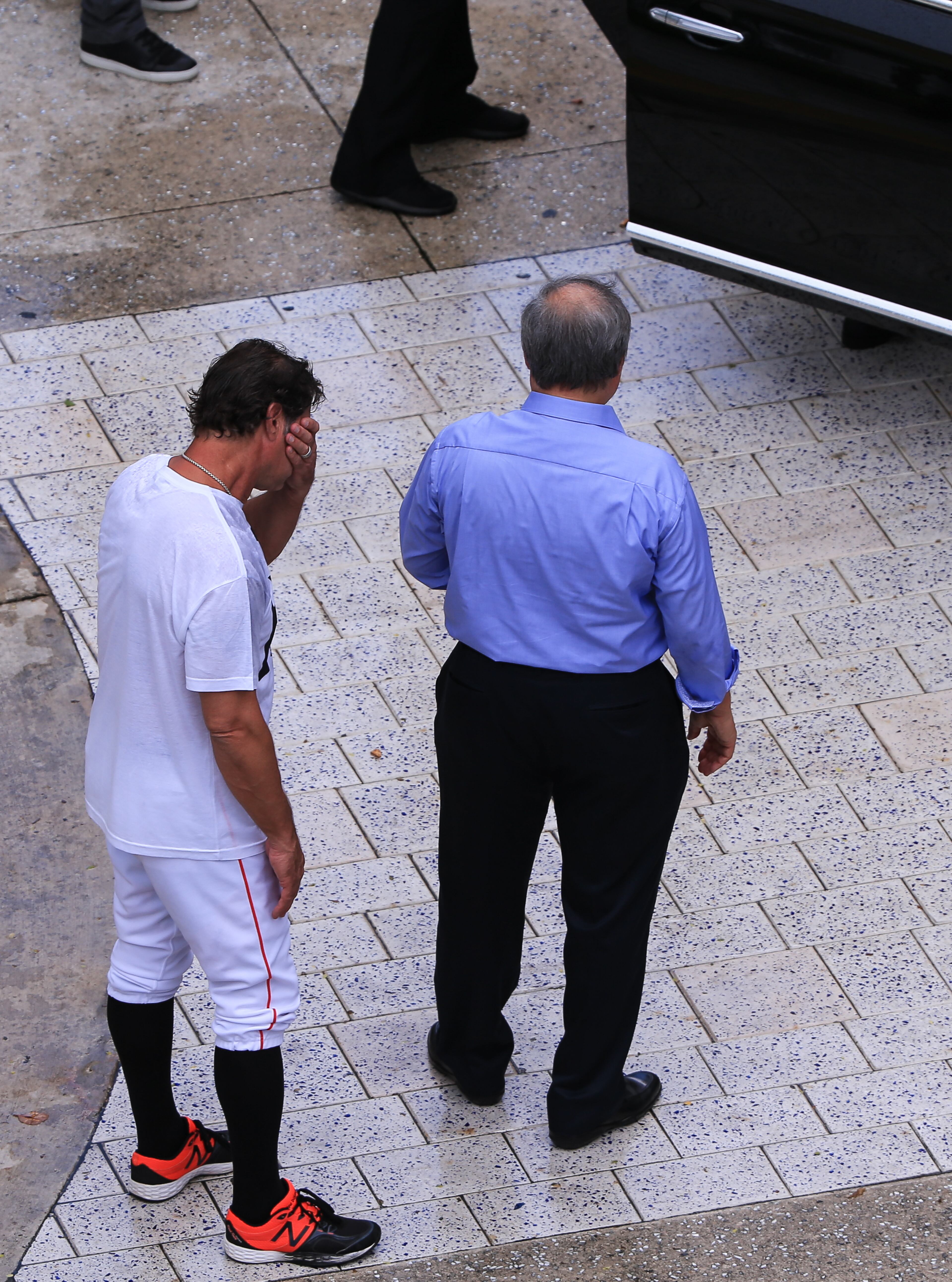 Miami Marlins owner Jeffrey Loria, right, and manager Don Mattingly, left, await the late Jose Fernandez' mother Maritza Fernandez as Miami Marlins players and members of the Marlins organization and their fans surround the hearse carrying Miami Marlins pitcher Jose Fernandez to pay their respects on September 28, 2016 in Miami, Florida. Mr. Fernandez was killed in a weekend boat crash in Miami Beach along with two friends. (Photo by Rob Foldy/Getty Images)