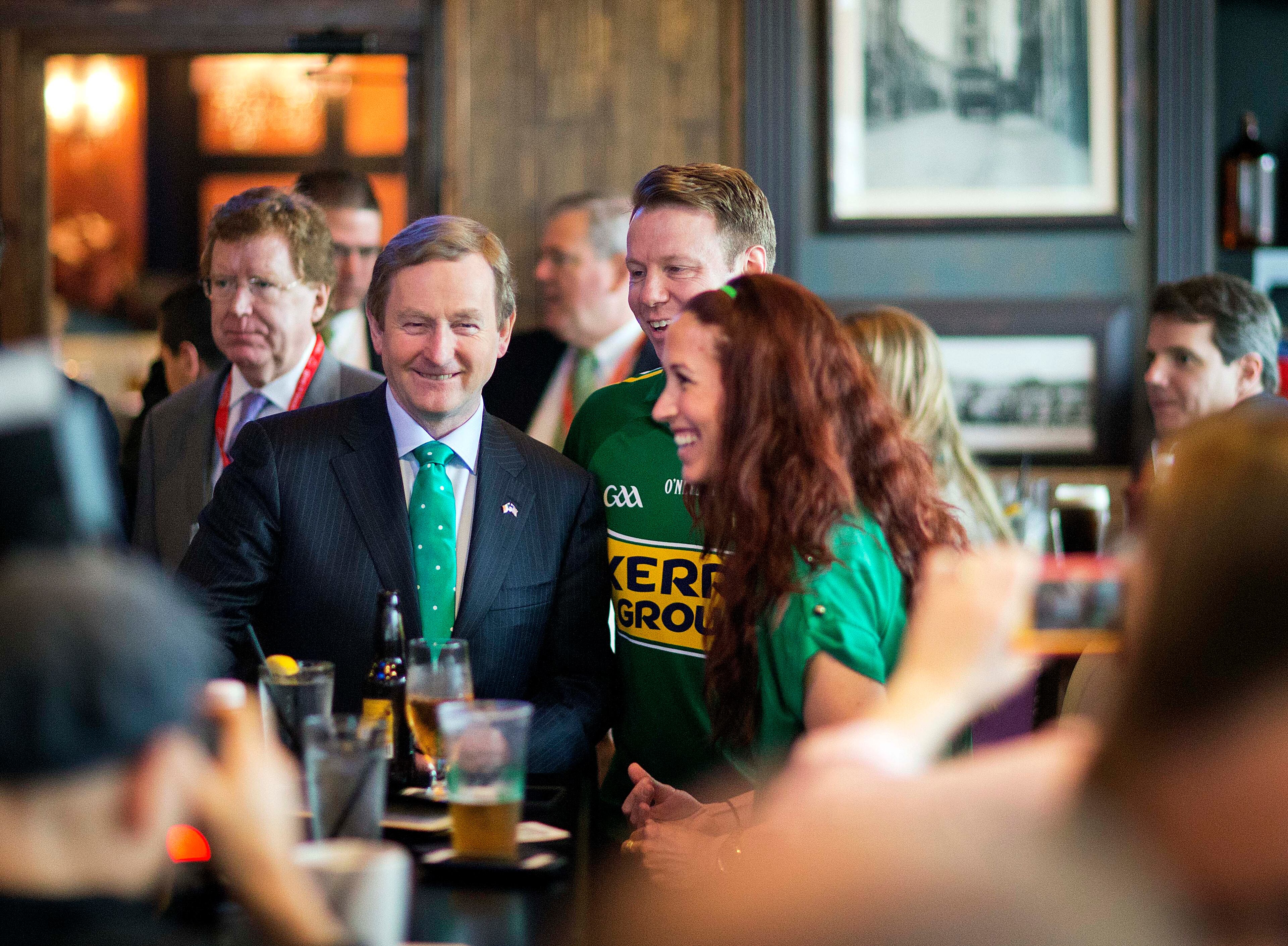 Irish Prime Minister Enda Kenny, left, talks with Jimmy Canty, originally of Kerry, Ireland, center, and Kathleen Fox, both living in Atlanta, as he greets customers at the grand opening of Fado Irish Pub in Midtown before serving as grand marshal of the city's St. Patrick's Day parade March 14, 2015, in Atlanta.