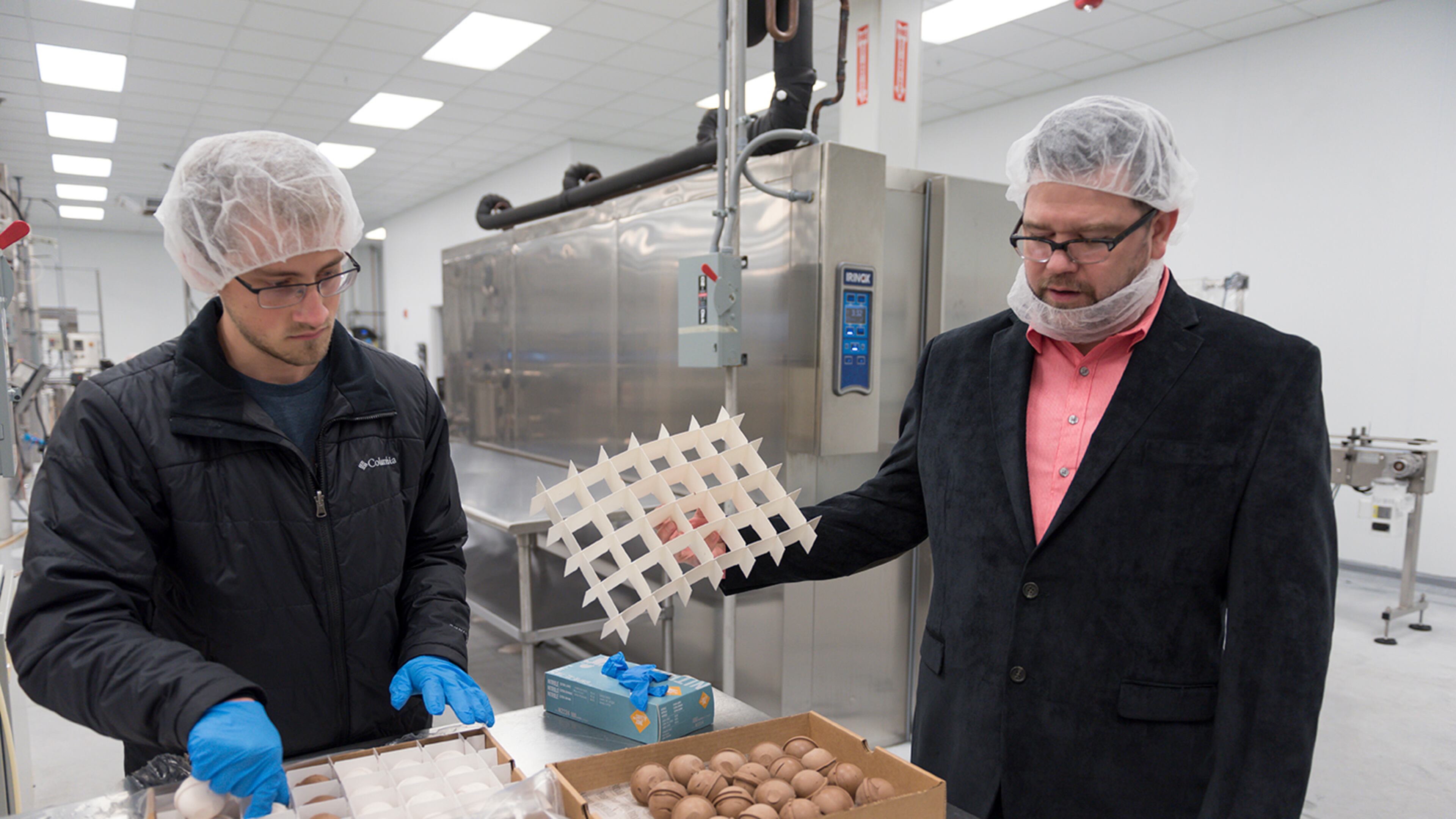 Keith Schroeder, right, founder and chief executive officer of High Road Ice Cream & Sorbet, and Grayson Shurett, left, a worker at High Road, examine ice cream scoops in High Road's factory in Marietta, Georgia (DAVID BARNES / SPECIAL)