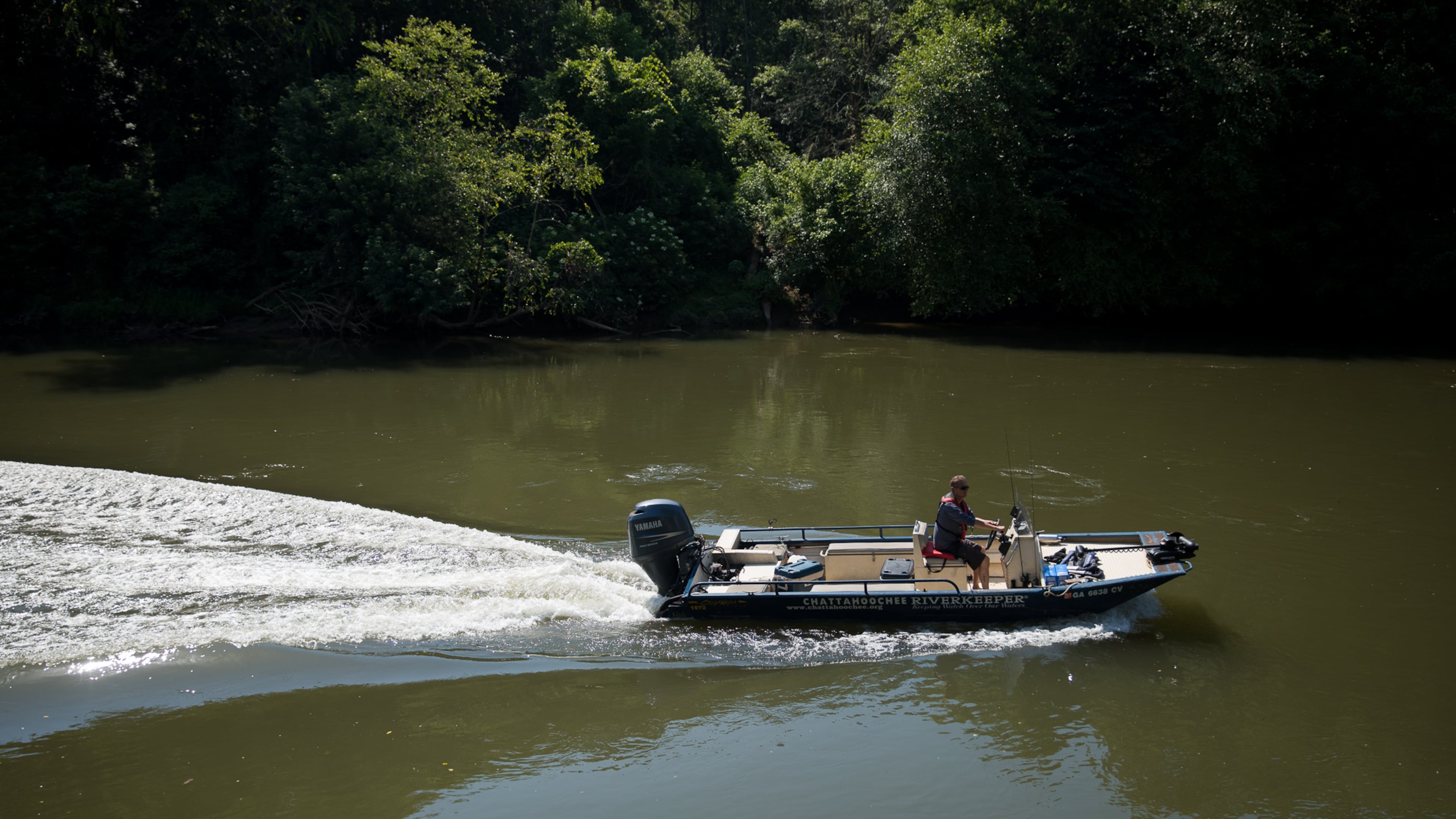 Chattahoochee Riverkeeper Executive Director Jason Ulseth scours the river for irregularities during a boat patrol ride with the organization on June 12. (Riley Bunch/AJC 2024)
