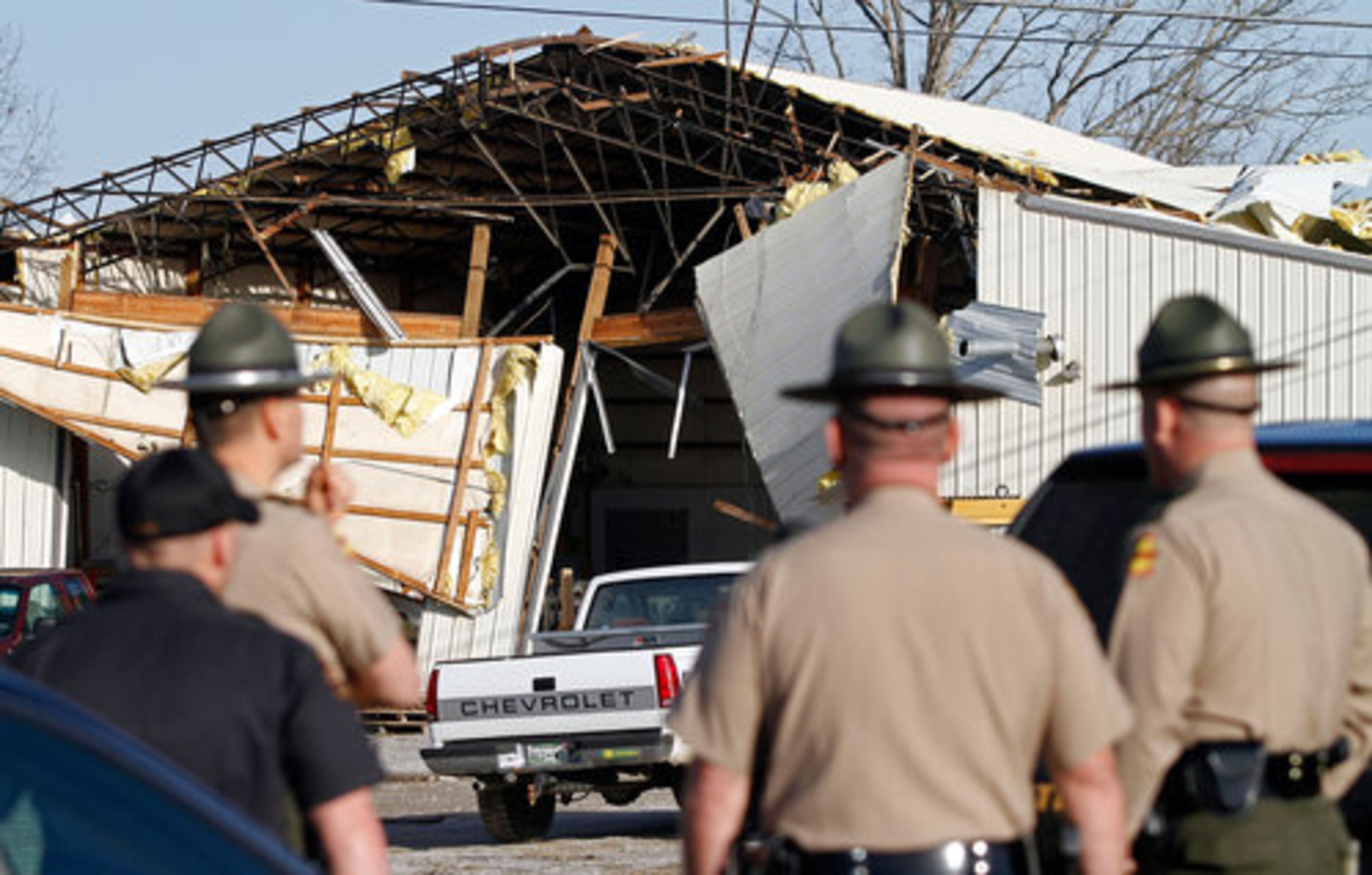 Tennessee State Troopers look at damage to a building near Crossville, Tenn.