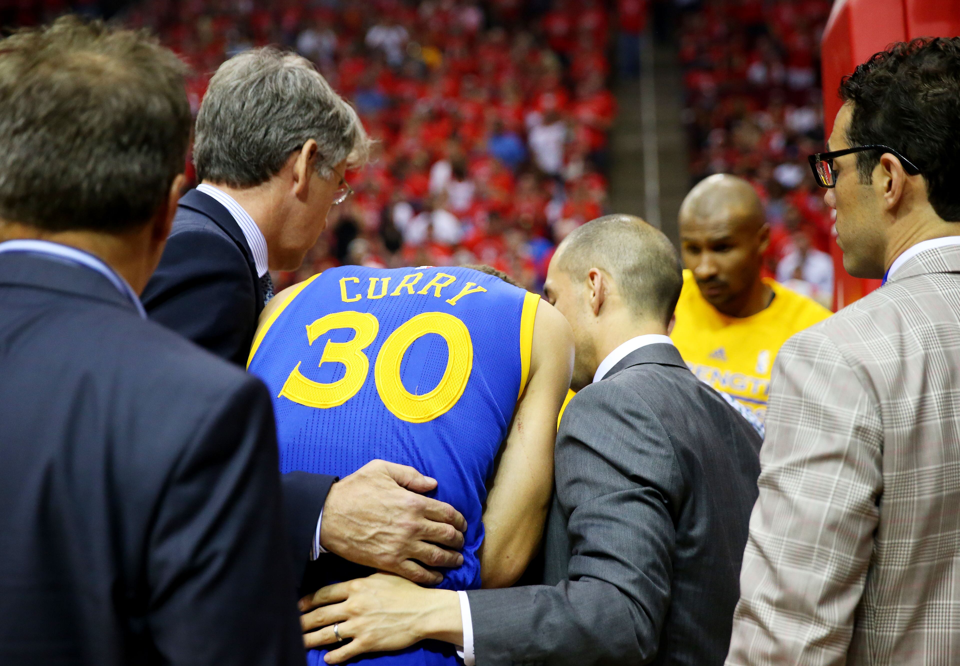 HOUSTON, TX - MAY 25: Stephen Curry #30 of the Golden State Warriors is helped off of the court after being injured in the second quarter against the Houston Rockets during Game Four of the Western Conference Finals of the 2015 NBA Playoffs at Toyota Center on May 25, 2015 in Houston, Texas. NOTE TO USER: User expressly acknowledges and agrees that, by downloading and or using this photograph, user is consenting to the terms and conditions of Getty Images License Agreement. (Photo by Ronald Martinez/Getty Images)