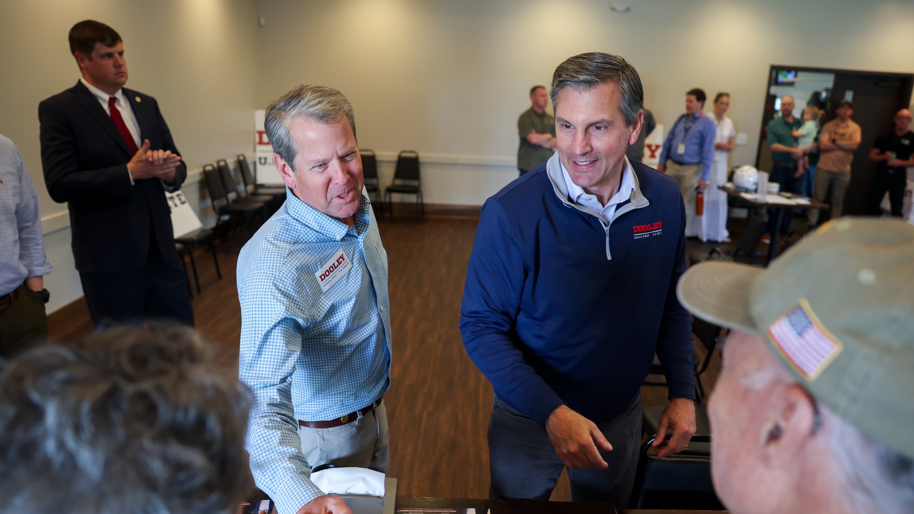 FILE - Gov. Brian Kemp, center left, and Republican U.S. Senate candidate Derek Dooley greet supporters at campaign stop for Dooley at Farmview Market in Madison, Ga., on May 8, 2026. (Arvin Temkar/Atlanta Journal-Constitution via AP, File)