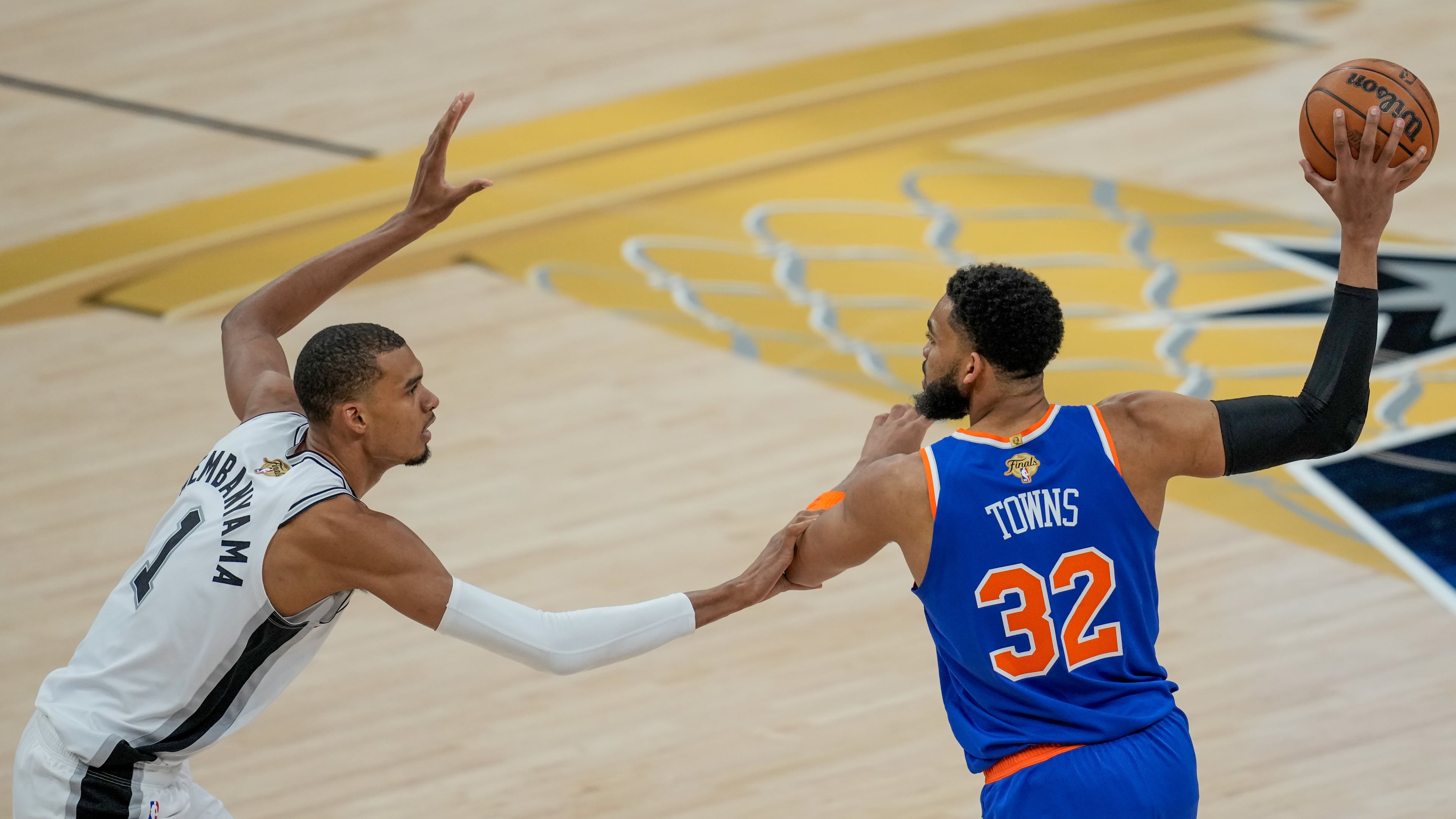 San Antonio Spurs forward Victor Wembanyama (1) defends against New York Knicks center Karl-Anthony Towns (32) during the first half of Game 2 of the NBA Finals basketball series, Friday, June 5, 2026, in San Antonio. (AP Photo/David J. Phillip)