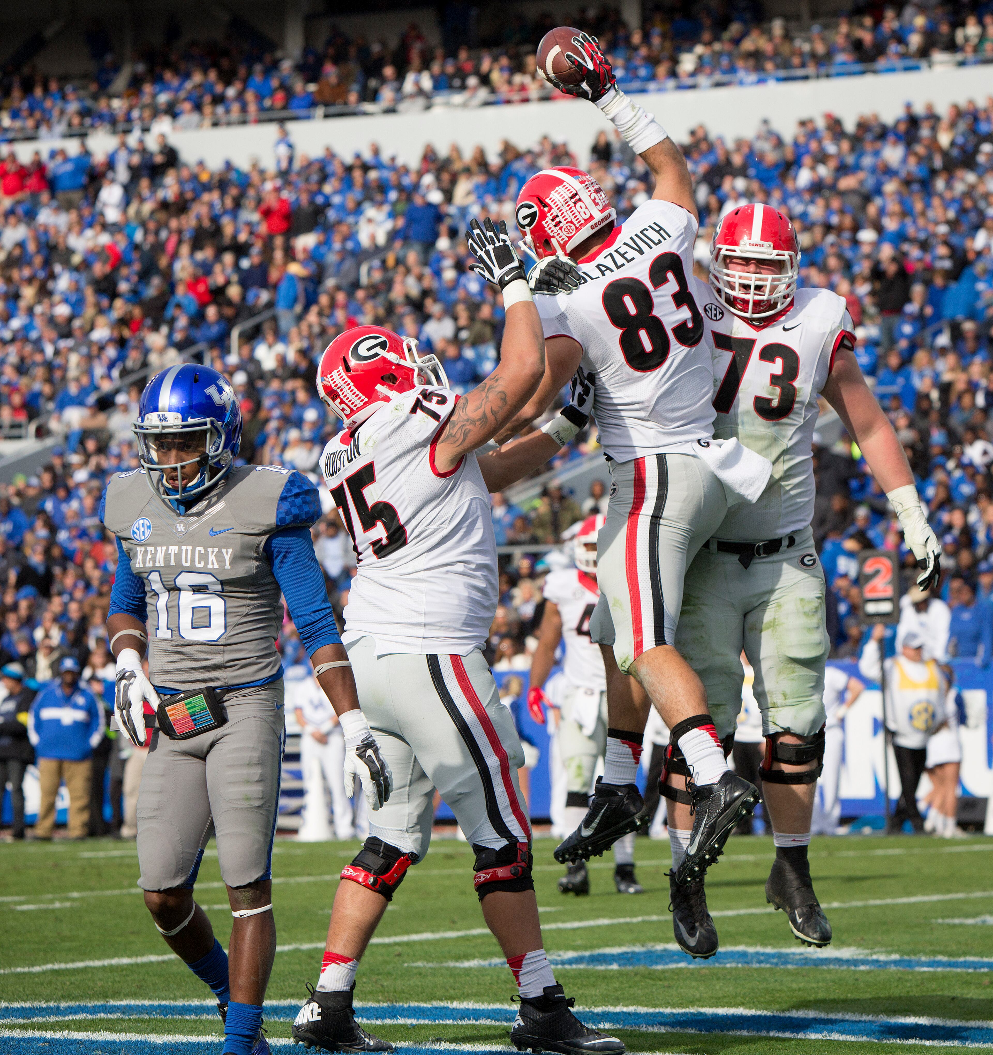 Georgia tight end Jeb Blazevich celebrates a touchdown reception with teammates, offensive tackle Kolton Houston, left, and guard Greg Pyke, right, during the second half of an NCAA college football game at Commonwealth Stadium in Lexington, Ky., Saturday, Nov. 8, 2014. At left is Kentucky cornerback Cody Quinn. Georgia beat Kentucky 63-31. (AP Photo/David Stephenson)