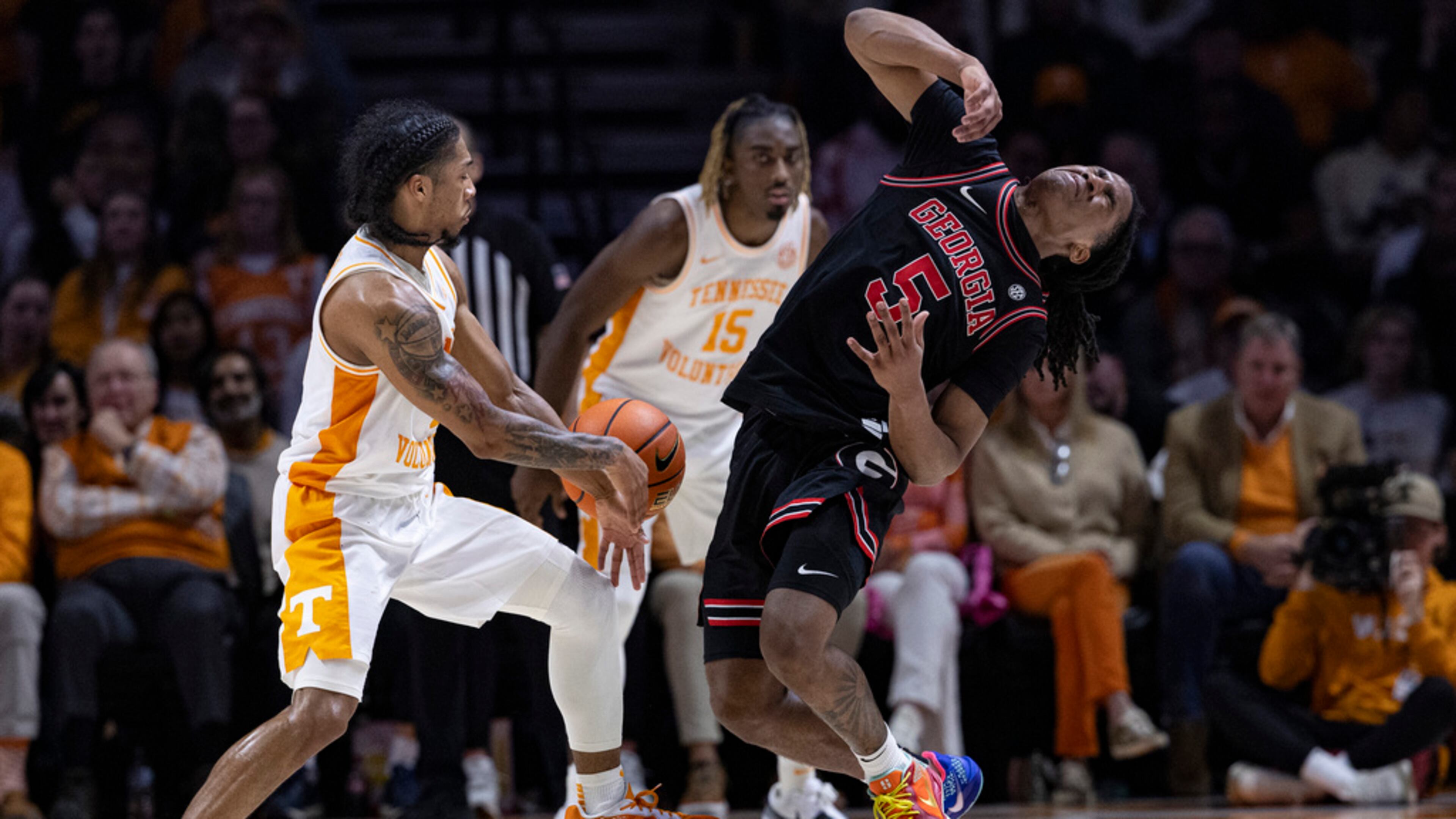 Georgia guard Silas Demary Jr. (5) falls back as he collides with Tennessee guard Zakai Zeigler (5) while battling for the ball during the first half of an NCAA college basketball game Wednesday, Jan. 15, 2025, in Knoxville, Tenn. (AP Photo/Wade Payne)