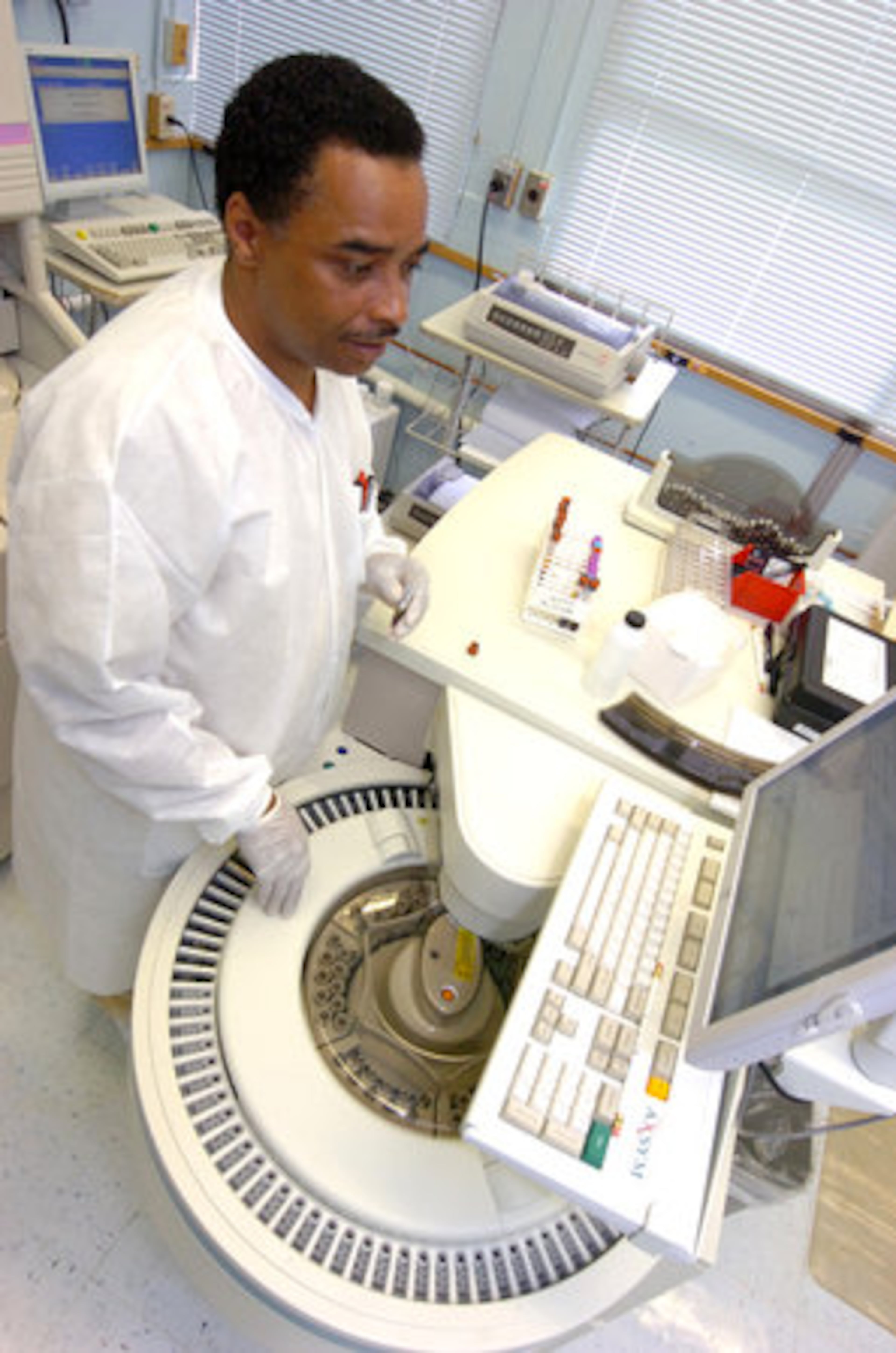 Laboratory technician Stanford Hollister shows the Abbott AXSYM, a machine for drug monitoring.