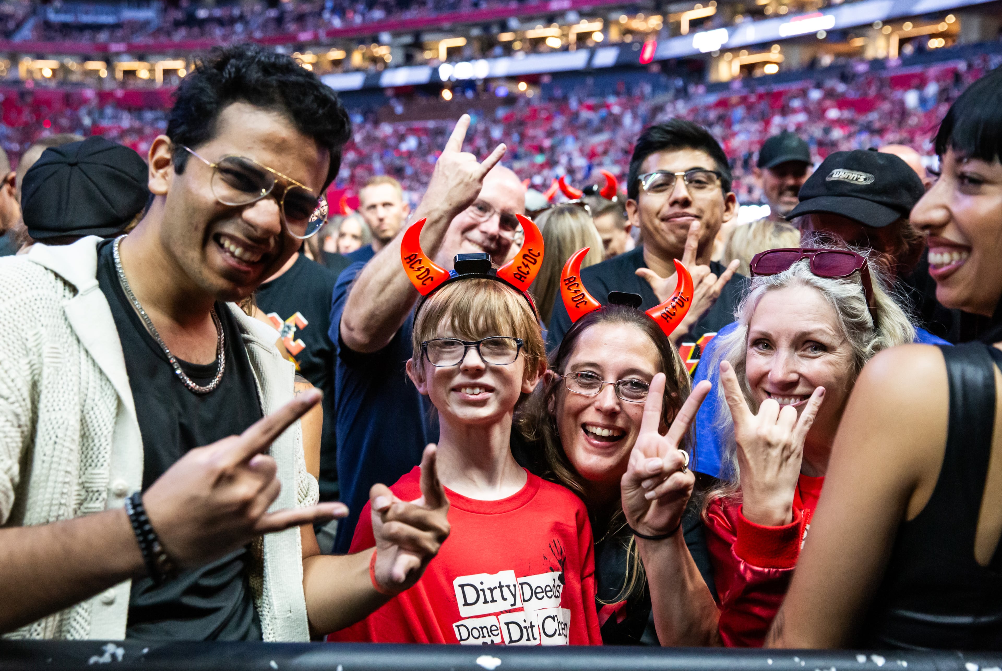Fans give the devil horns signs at the AC/DC concert on Thursday at Mercedes-Benz Stadium. (Ryan Fleisher for the AJC)
