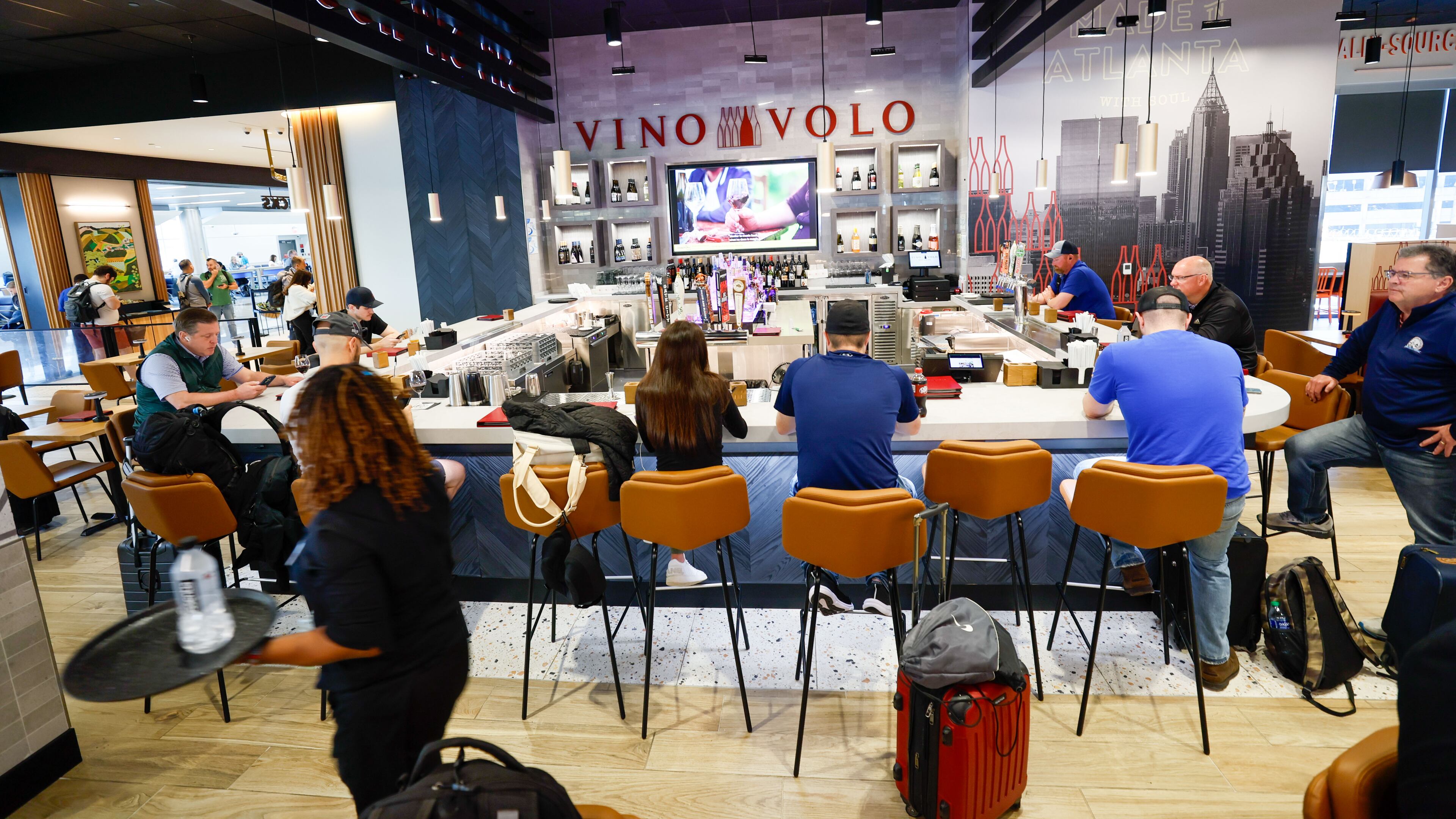 Travelers dine at Vino Volo in the new location in Terminal T at Hartsfield-Jackson International Airport on Wednesday, May 1, 2024, in Atlanta. Vino Volo is one of multiple shops opened last year by concessions giant Paradies Lagardère, a global corporation that offers retail and dining experiences to travelers. (Miguel Martinez/AJC)