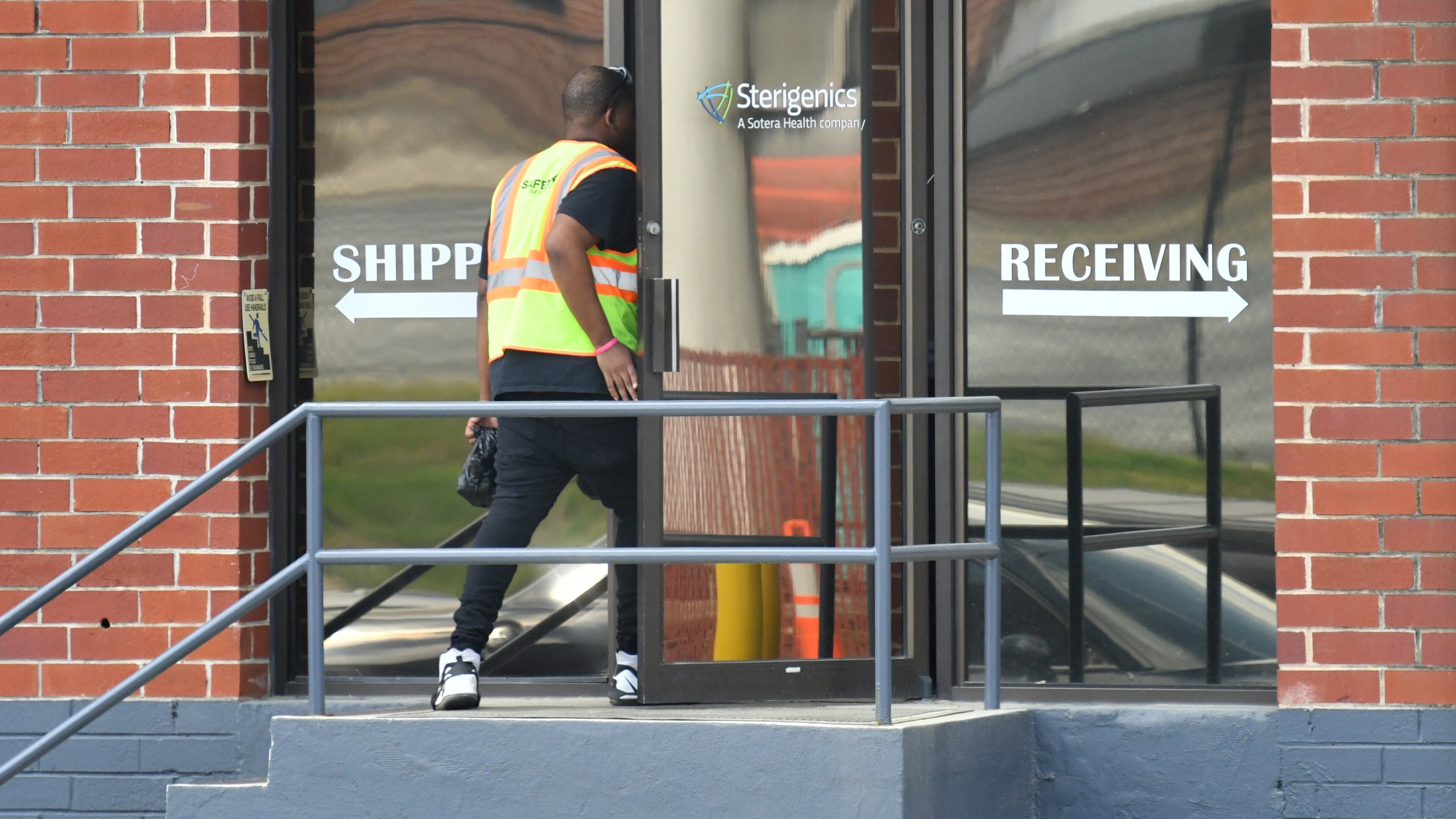 A man wearing a safety vest enters The Sterigenics plant in Smyrna on Thursday, March 26, 2020. Sterigenics recently resumed operations pending the outcome of an ongoing legal dispute with the county over its permitting. (Hyosub Shin / Hyosub.Shin@ajc.com)