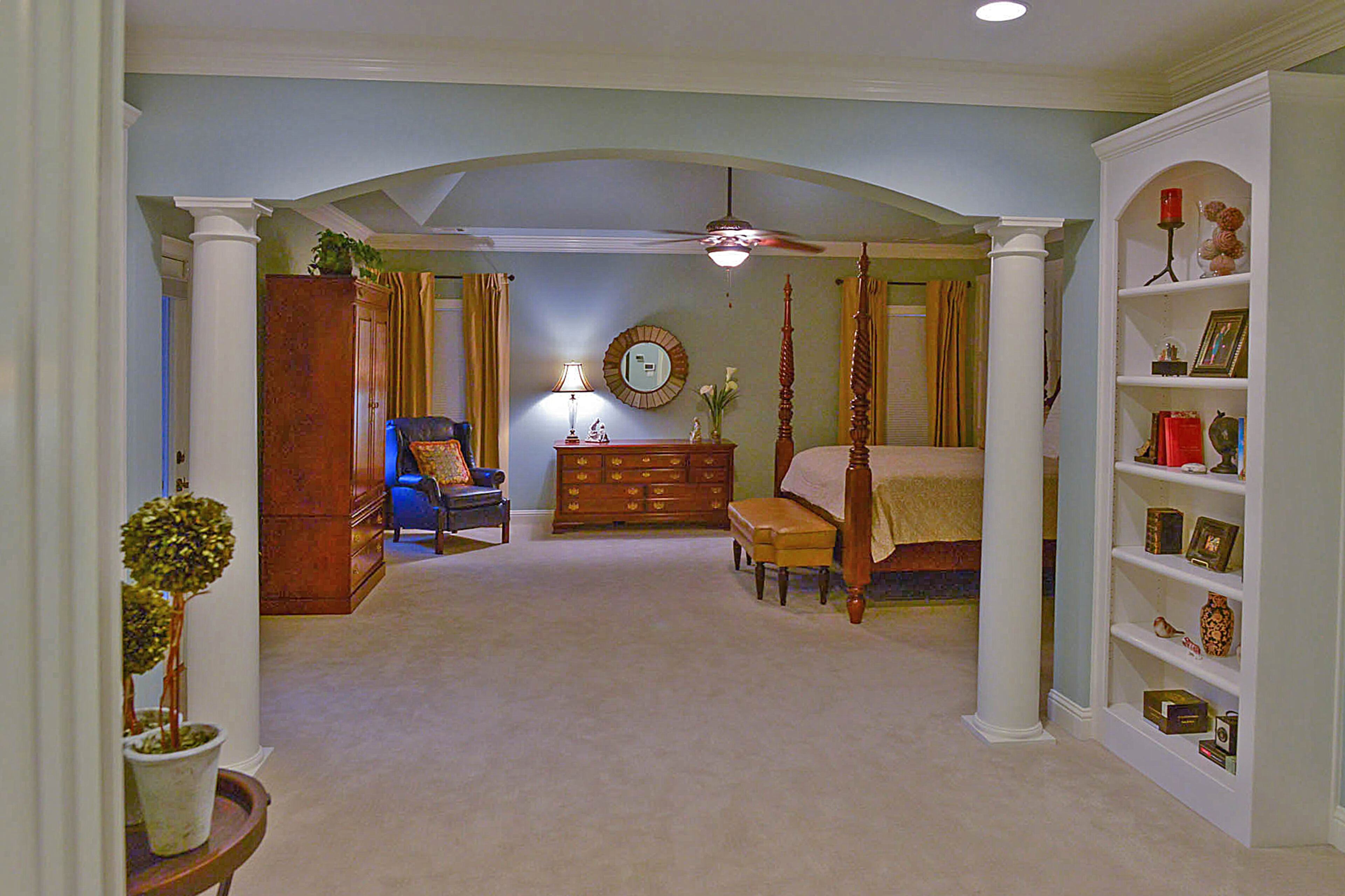 The master bedroom features architectural elements such as the archway with columns. The home was built in 2002 by Monte Hewett Homes and they painted the bedroom Silvermist, a Sherwin-Williams hue.